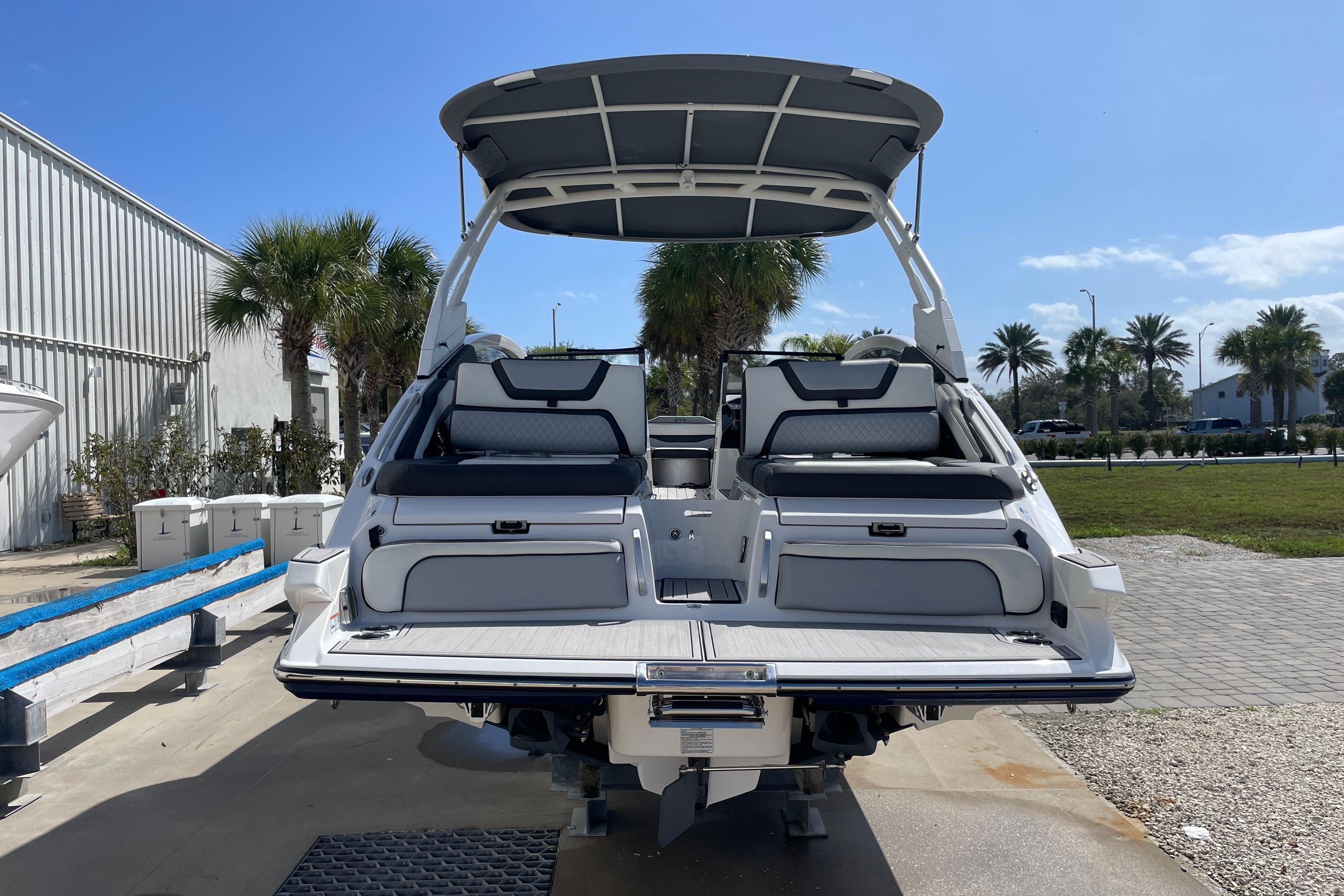 2021 Yamaha Boats 275SE with sleek design, docked under clear blue sky.