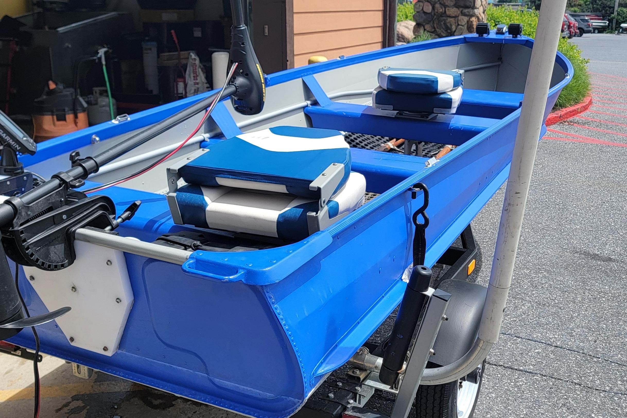 1966 Sea Nymph V-14 blue boat with motor and seating, parked on a trailer.