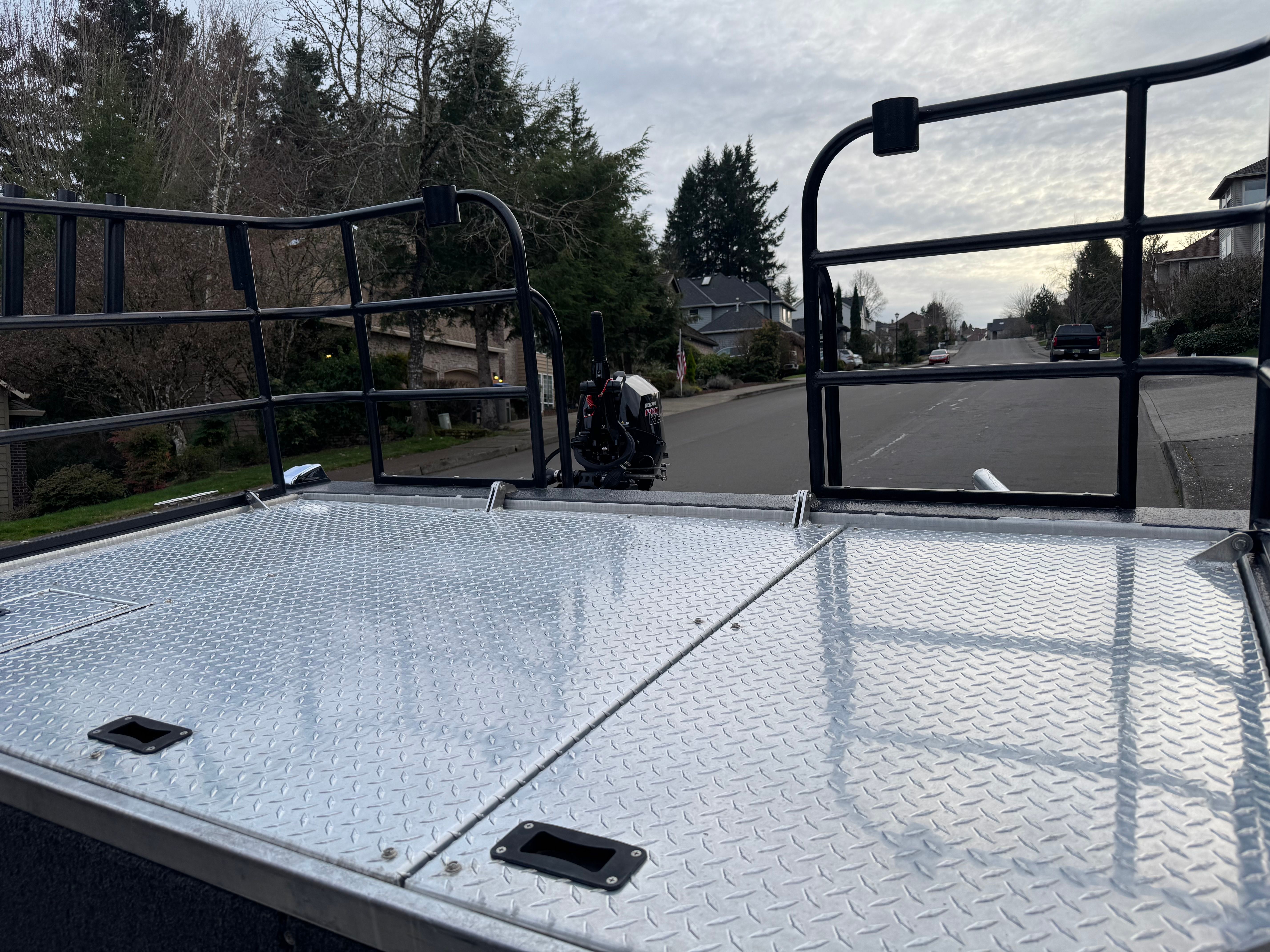 Custom RMX 24 boat on trailer, street in background.
