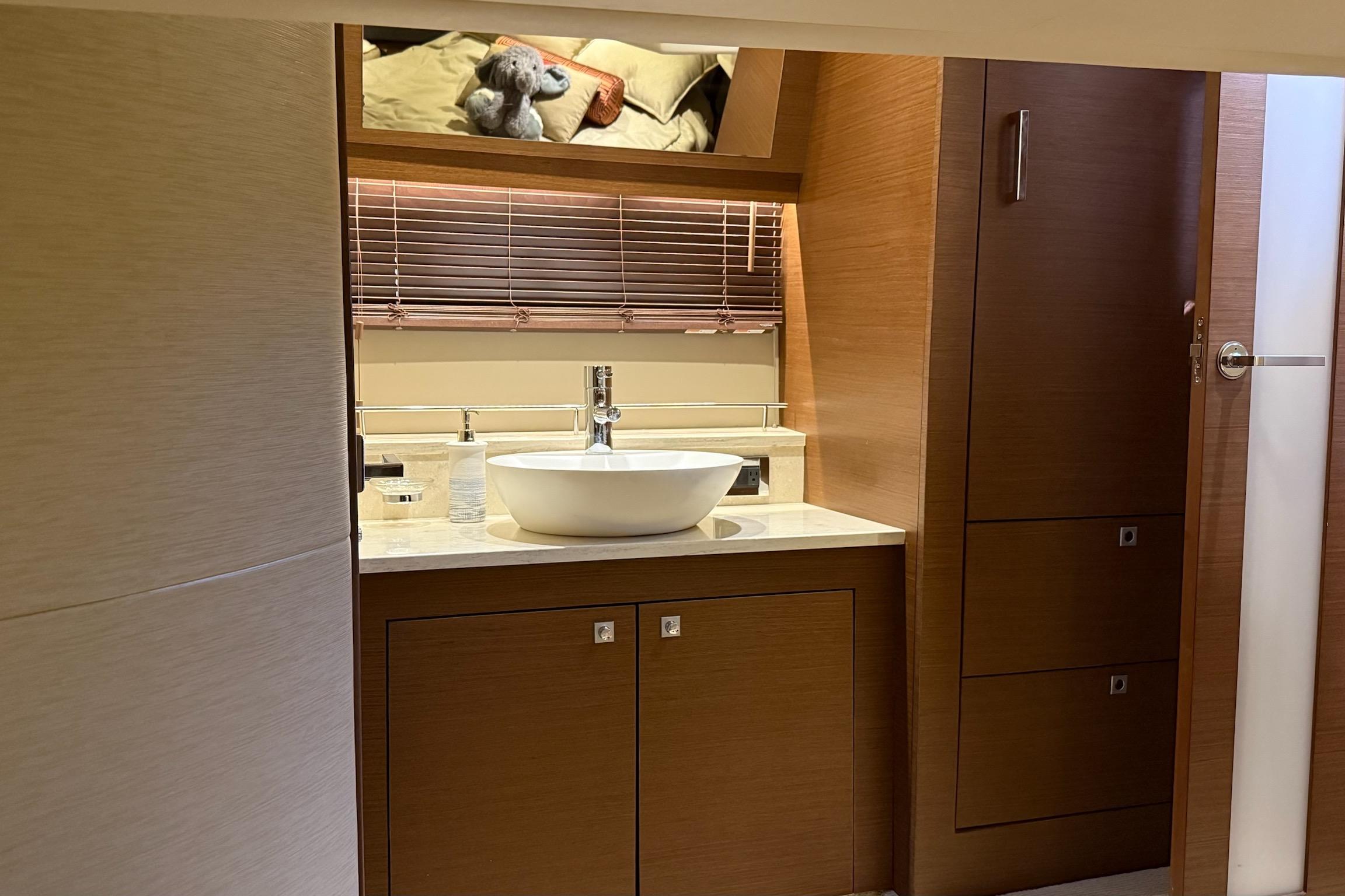 Luxurious bathroom interior of 2015 Sea Ray 470 Sundancer yacht with modern sink and wooden cabinetry.