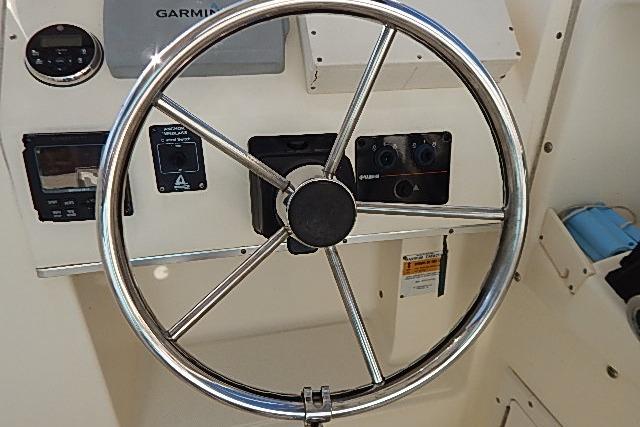 Steering wheel and controls of a 2003 World Cat 270 EC boat.