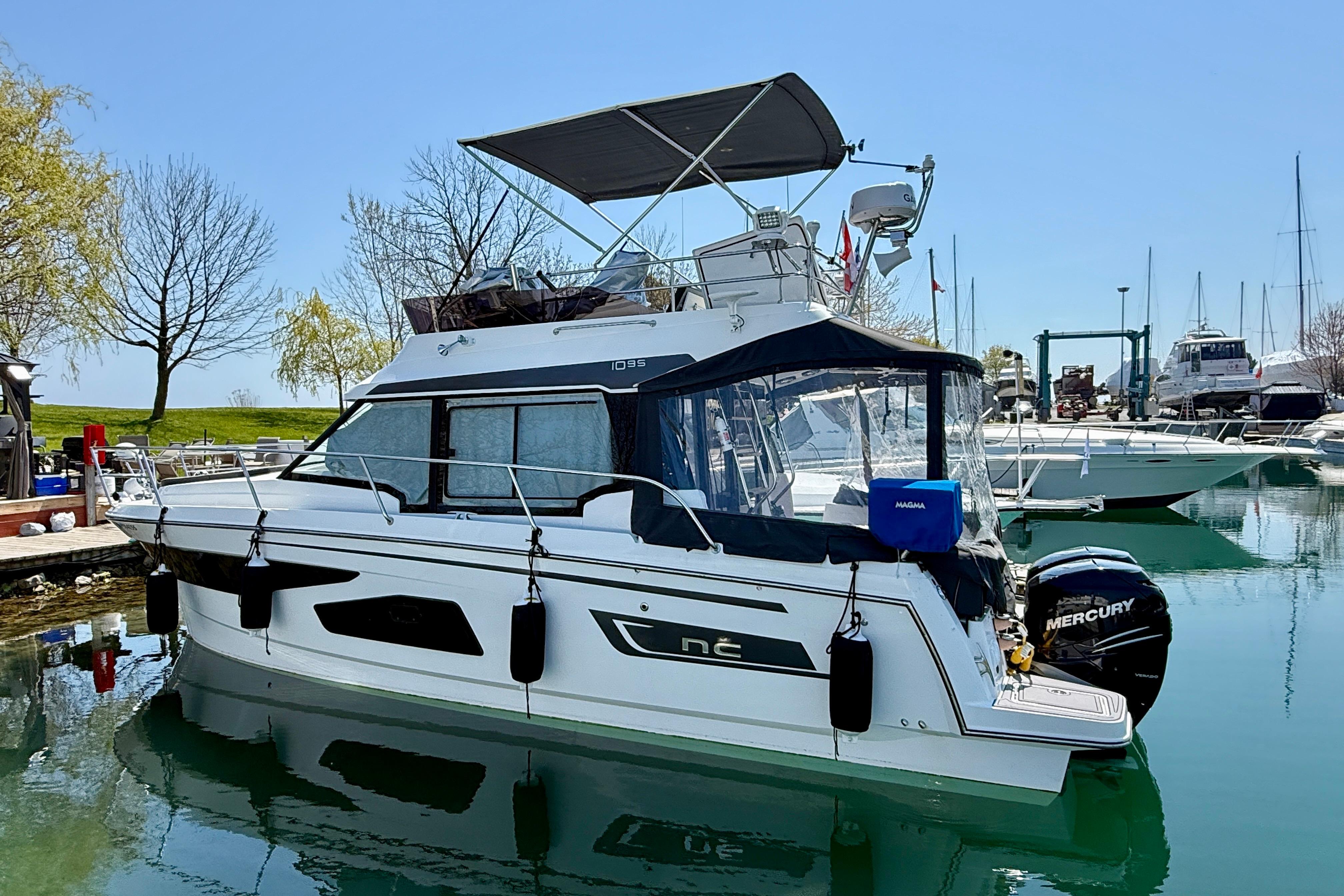 2022 Jeanneau NC 1095 Fly yacht docked in a marina under clear blue skies.