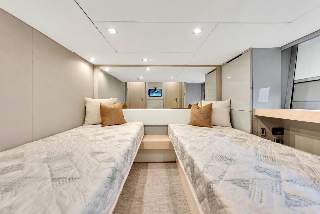 Luxurious twin cabin interior of 2012 Fairline Targa 58 yacht, featuring modern design and cozy bedding.
