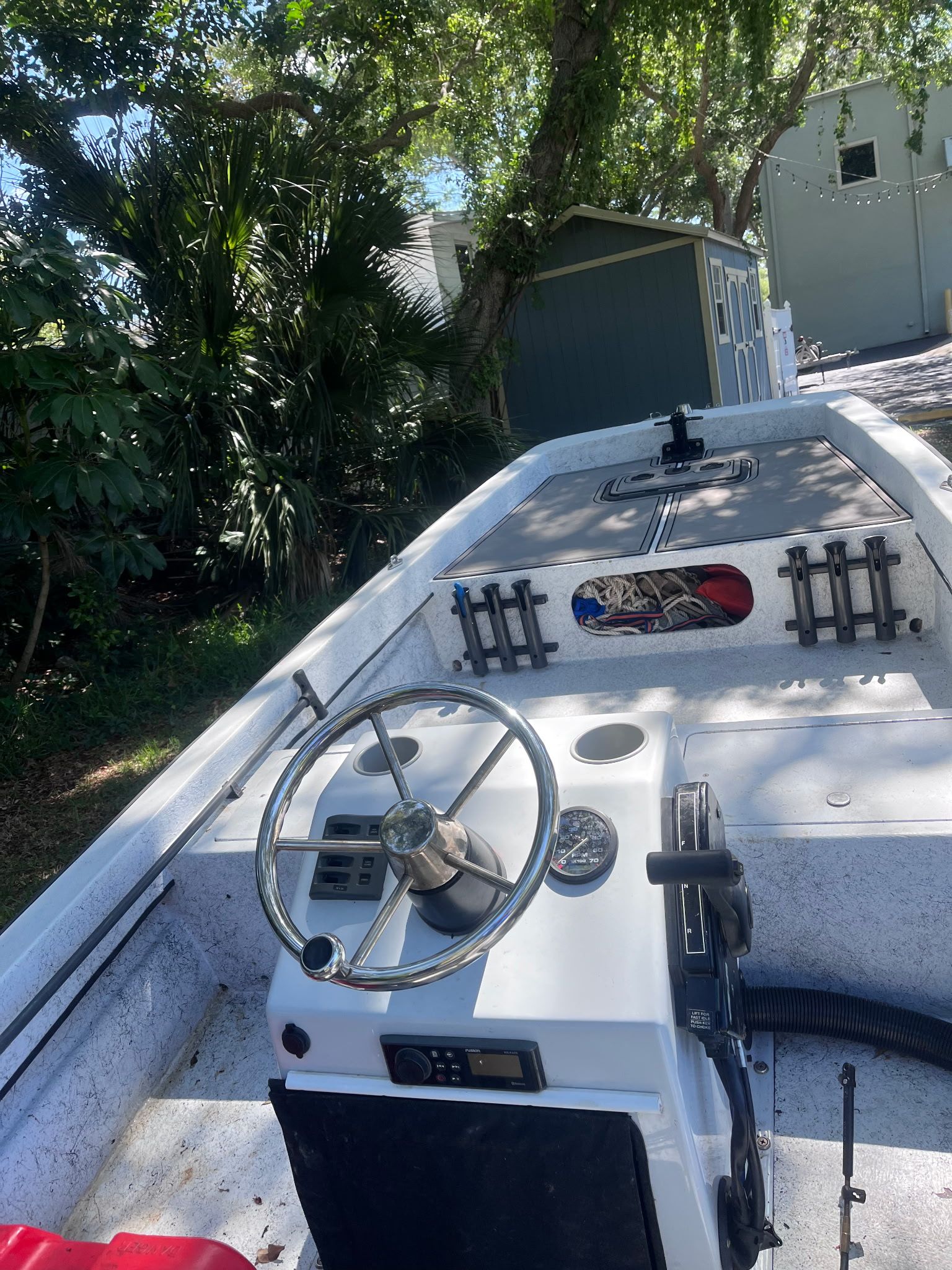 A 1974 McKee Craft Skiff with a helm and seating area, surrounded by trees.