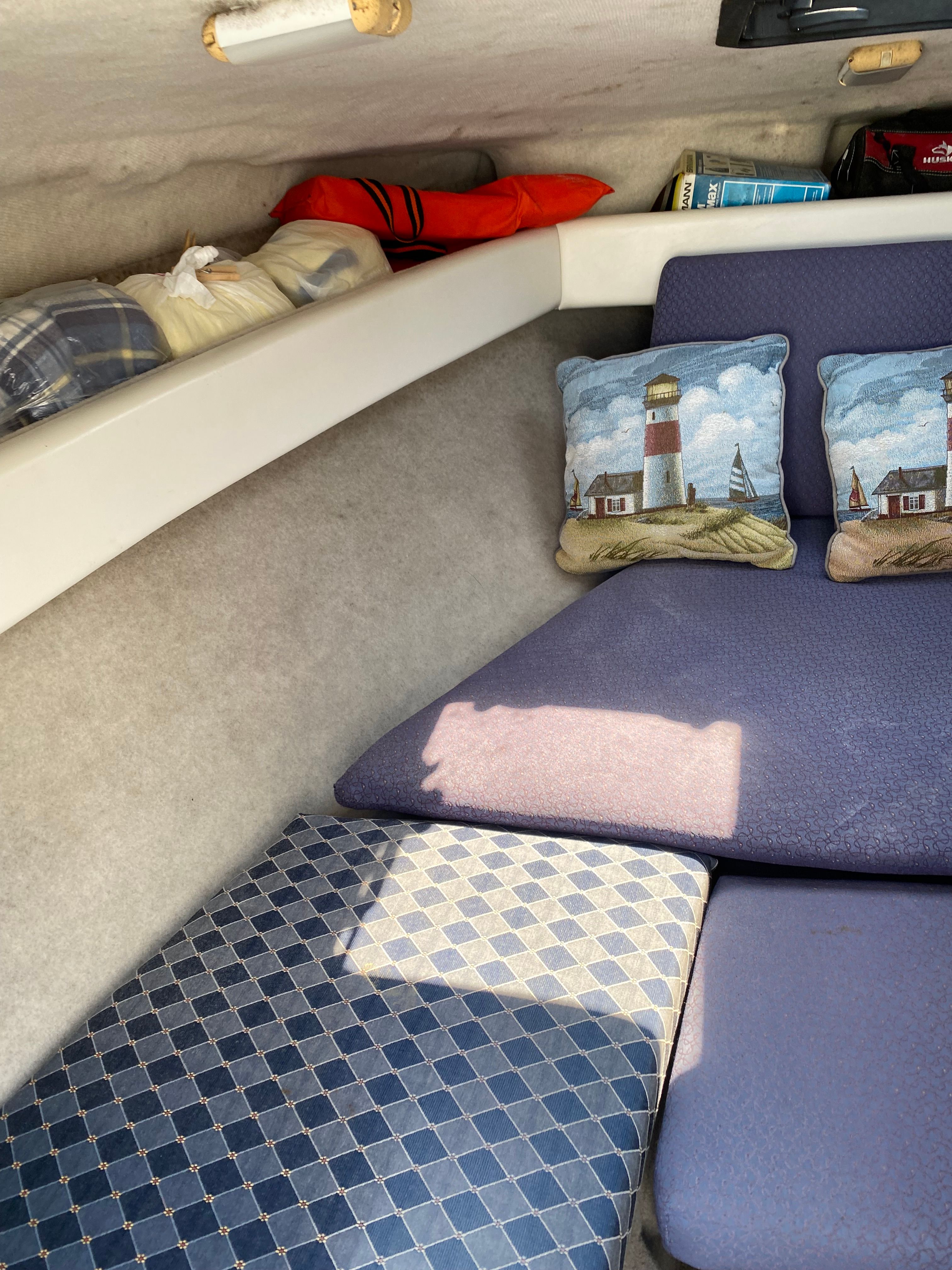 Interior of a 2003 Bayliner 2152 with cushions and storage space.