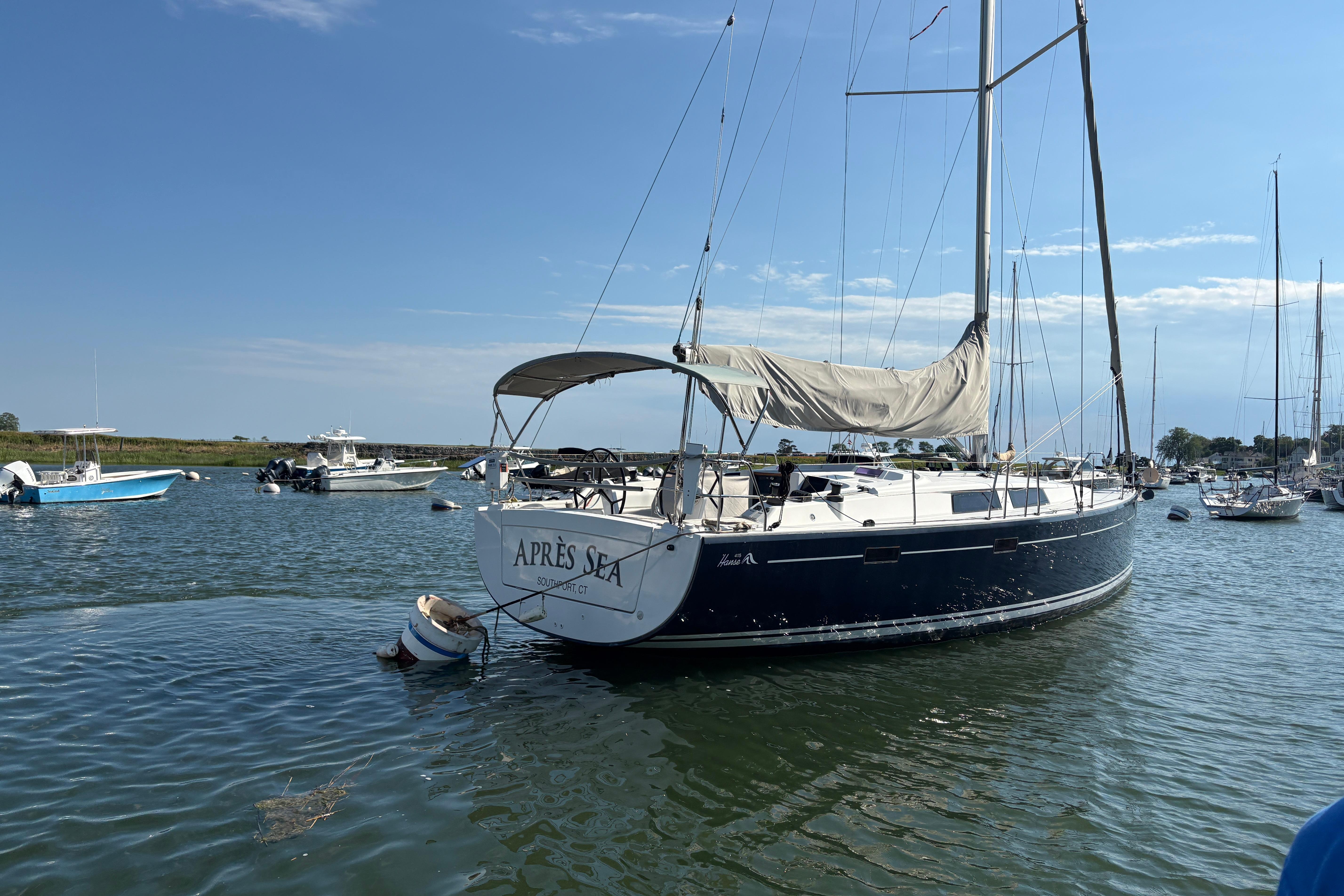 Sailboat Hanse 415, 2014 model, named "Après Sea," moored in a tranquil harbor.