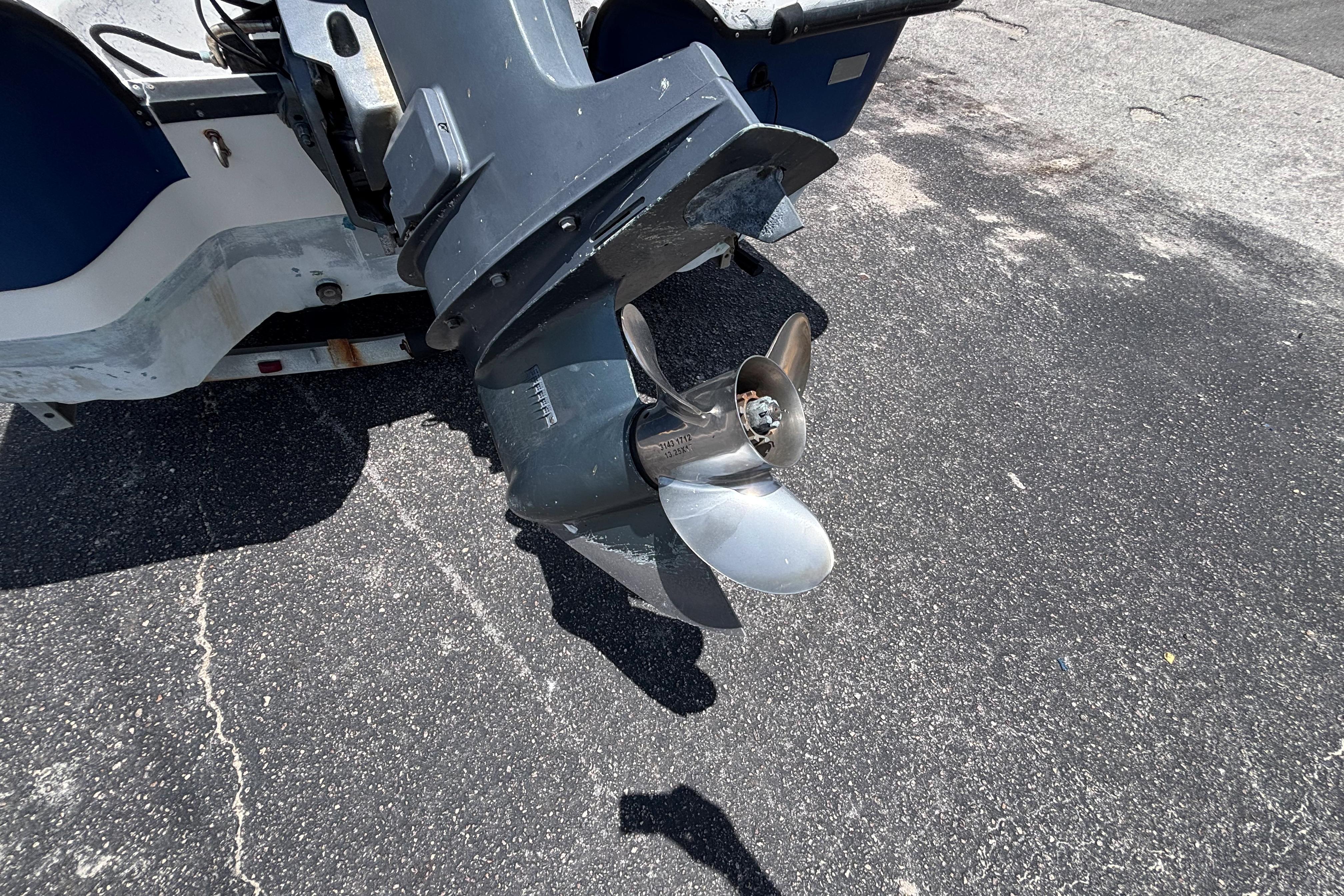Outboard motor of 2000 VIP 1880 BAY STEALTH boat on asphalt surface.