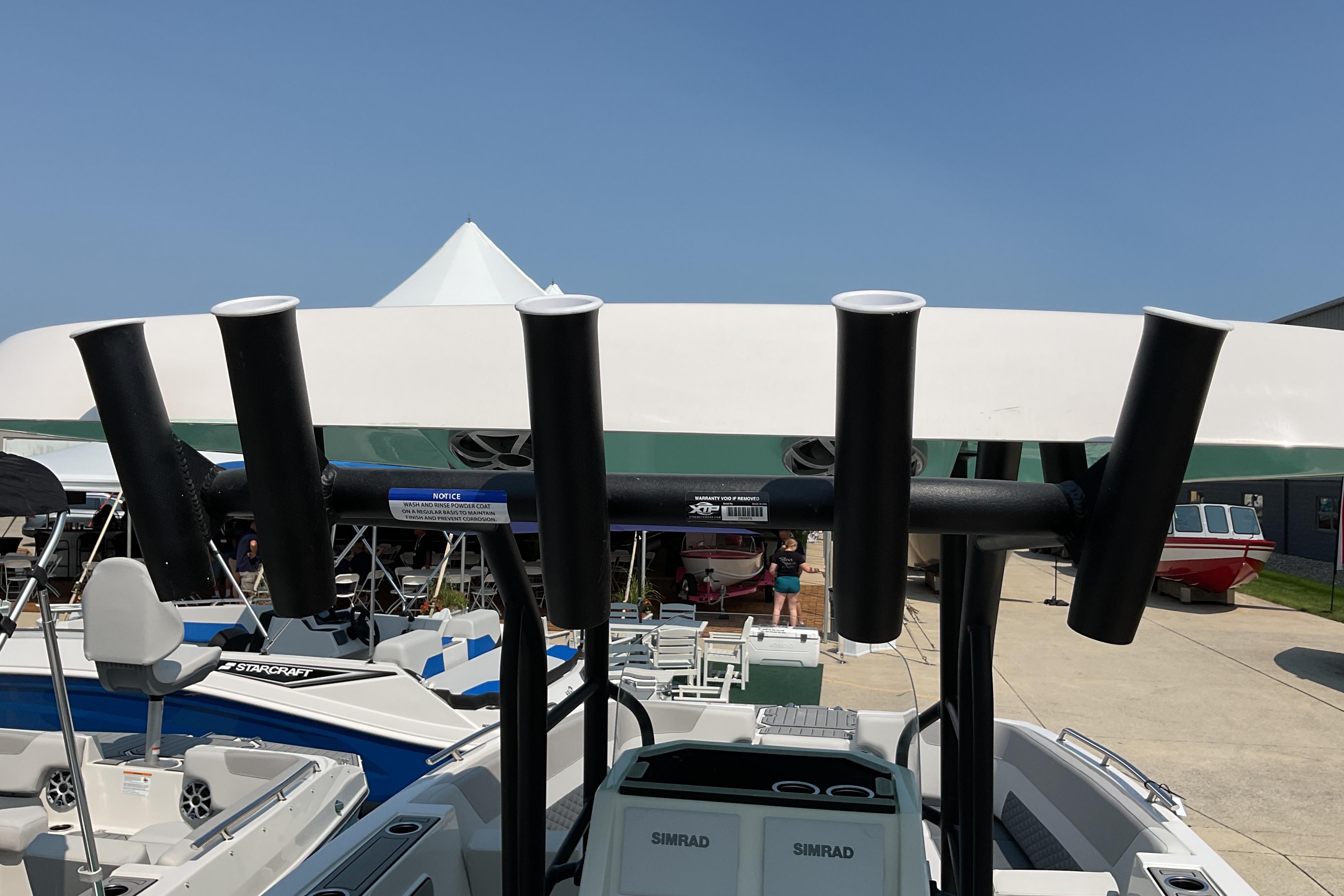 2026 Starcraft SVX 231 OB CC boat with rod holders and Simrad electronics, docked outdoors.