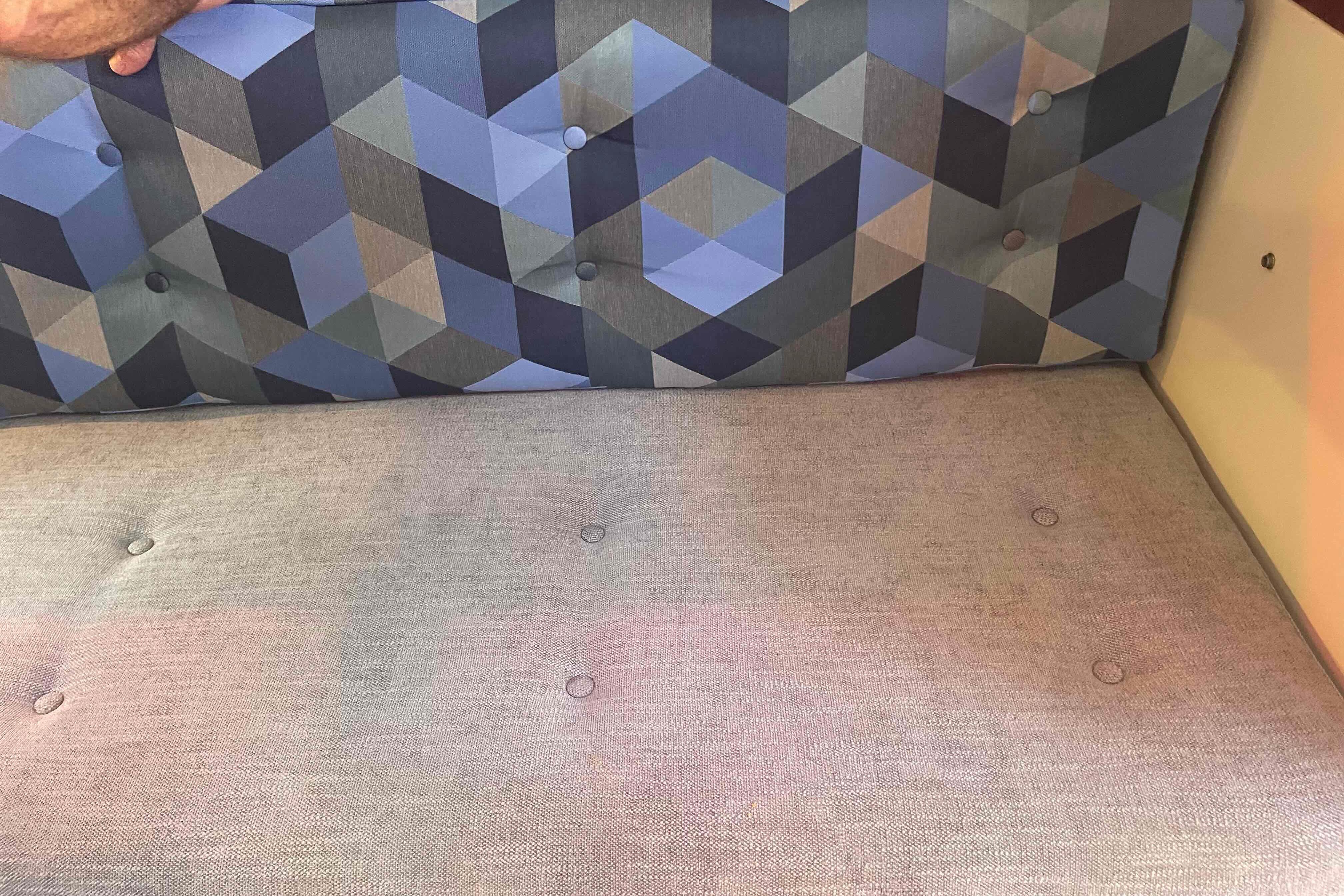 Cushioned seating with geometric pattern in a 1987 Pacific Seacraft 34 sailboat interior.
