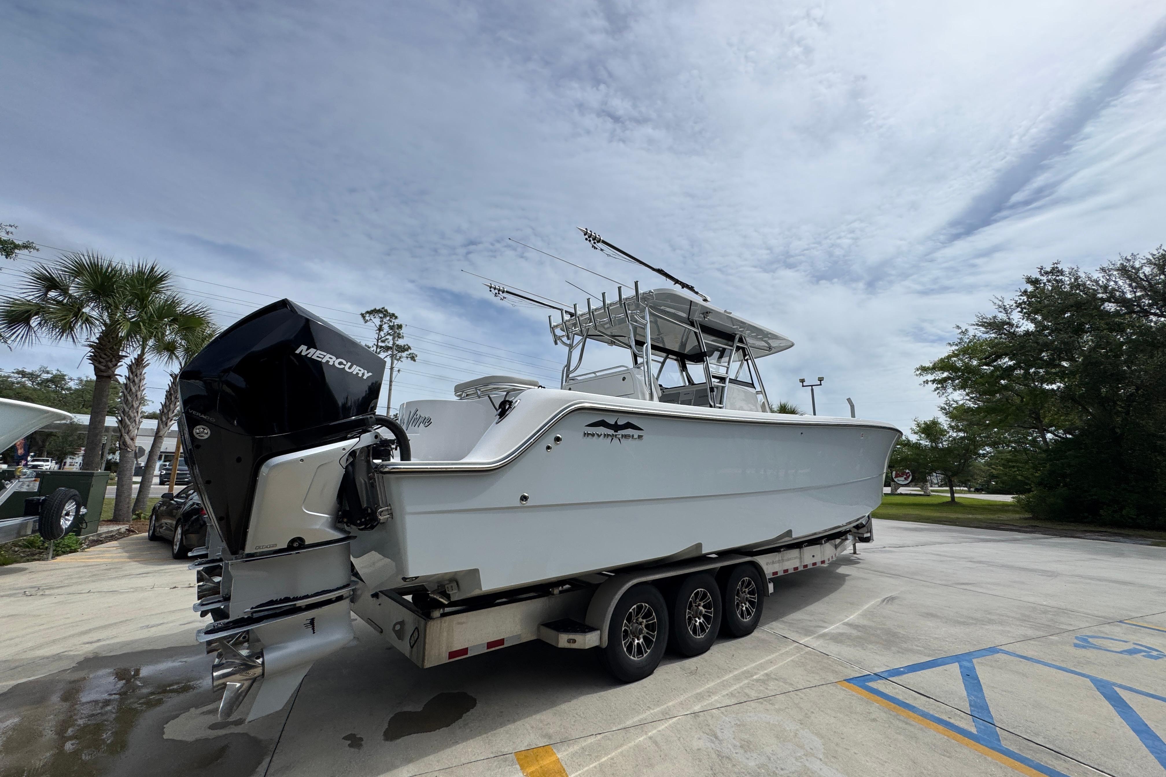 2020 Invincible 35 Catamaran on trailer with Mercury outboard engines, parked outdoors.