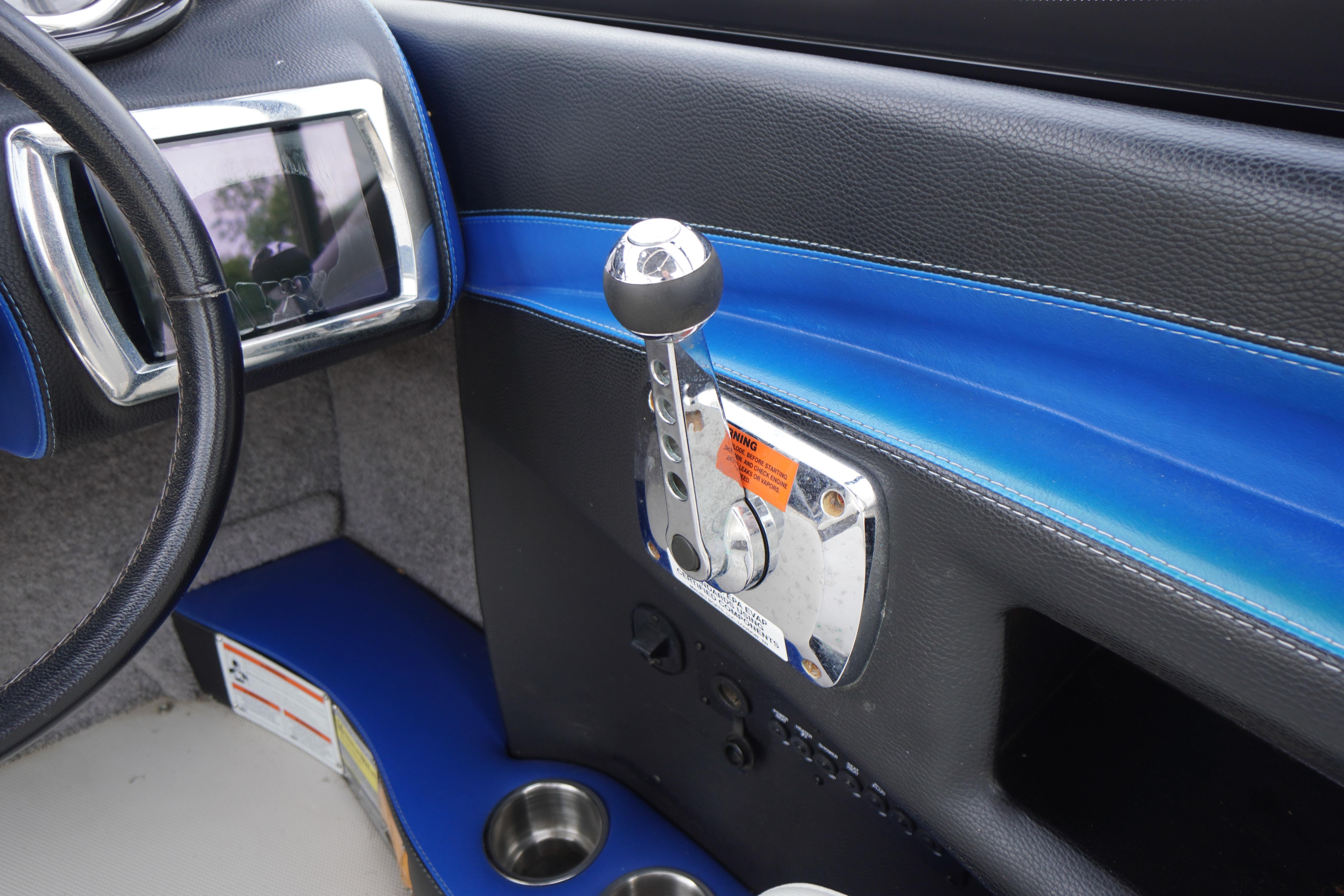 Interior of 2011 Malibu Wakesetter 21 VLX boat with steering wheel and throttle control.