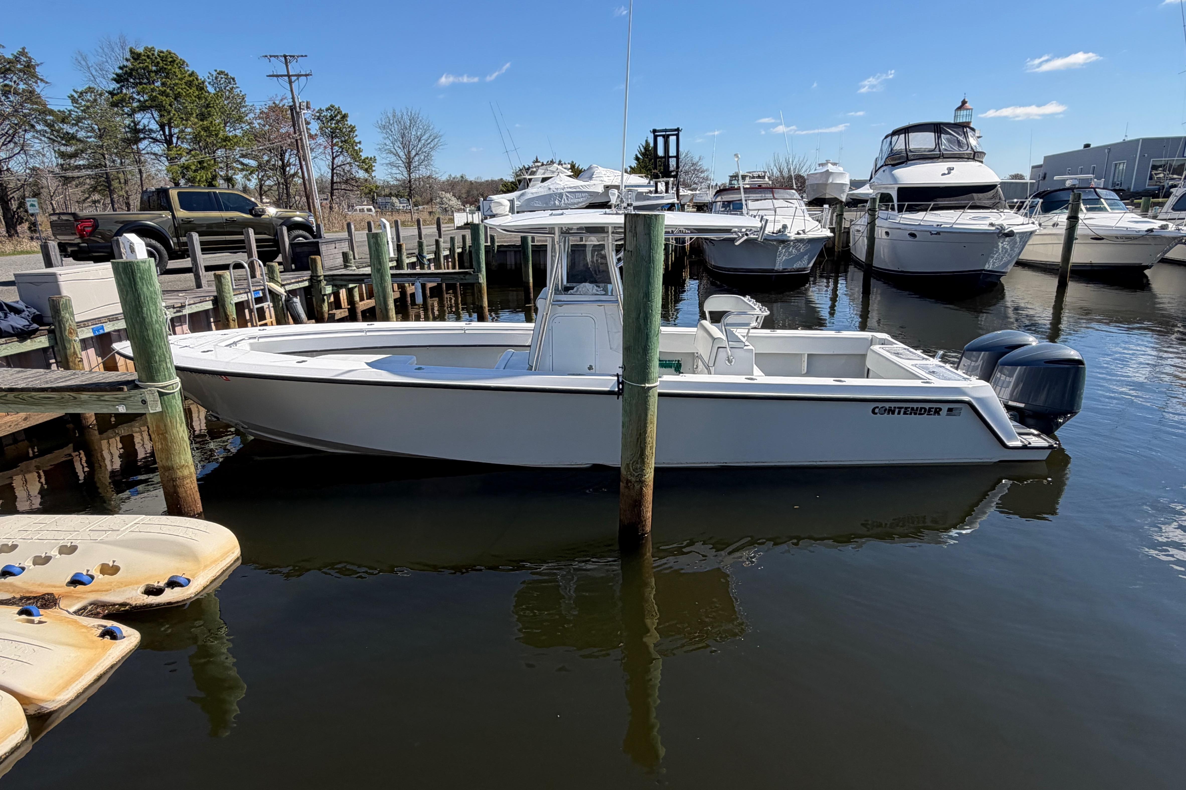 2015 Contender 32 ST boat docked at marina with other vessels.