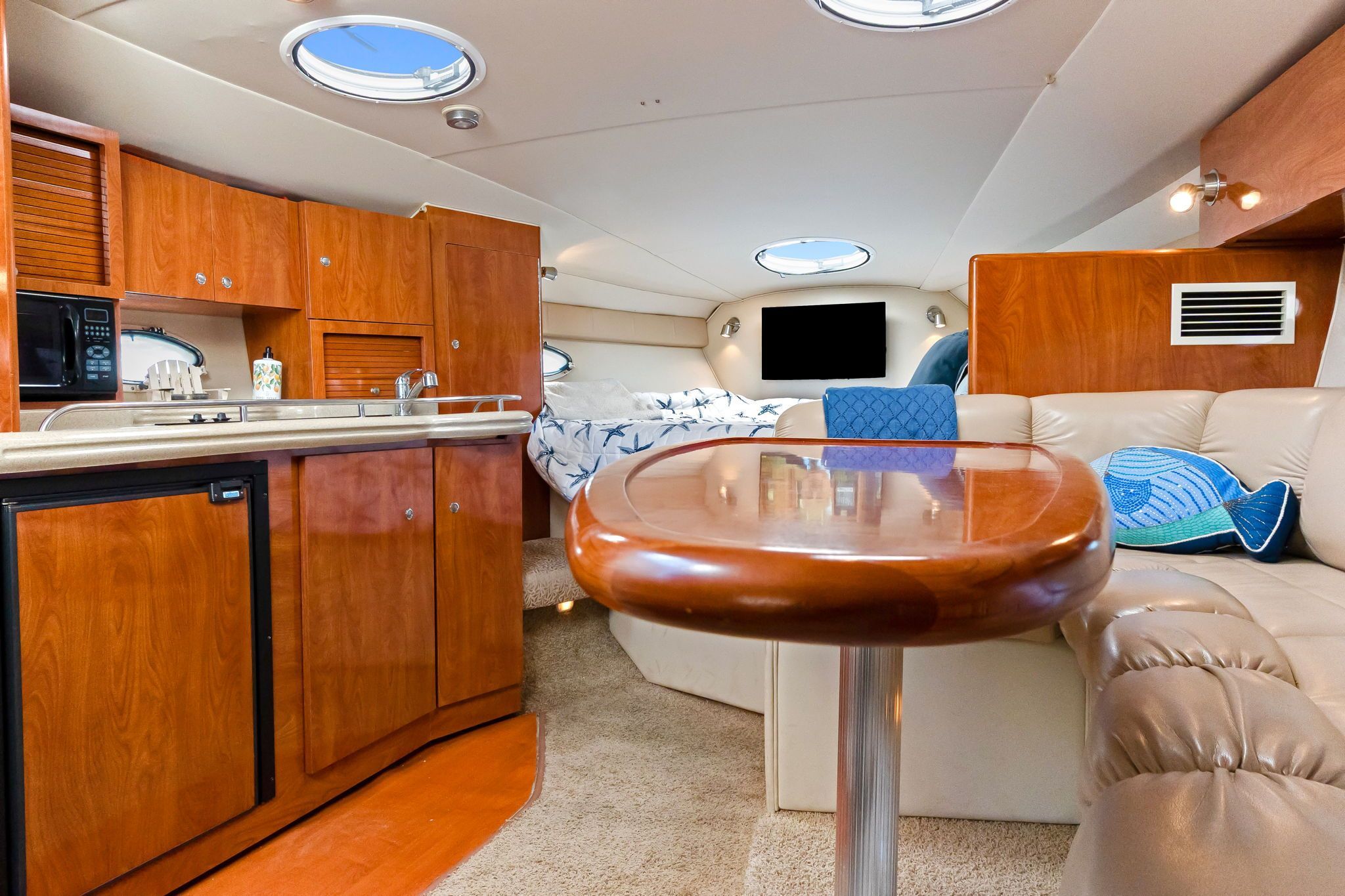 Interior of a 2007 Larson Cabrio 330 with wooden cabinetry and cozy seating area.