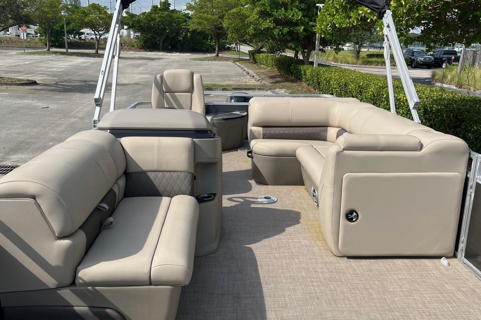 2025 Sun Tracker Fishin' Barge 20 DLX interior with beige seating and spacious layout.