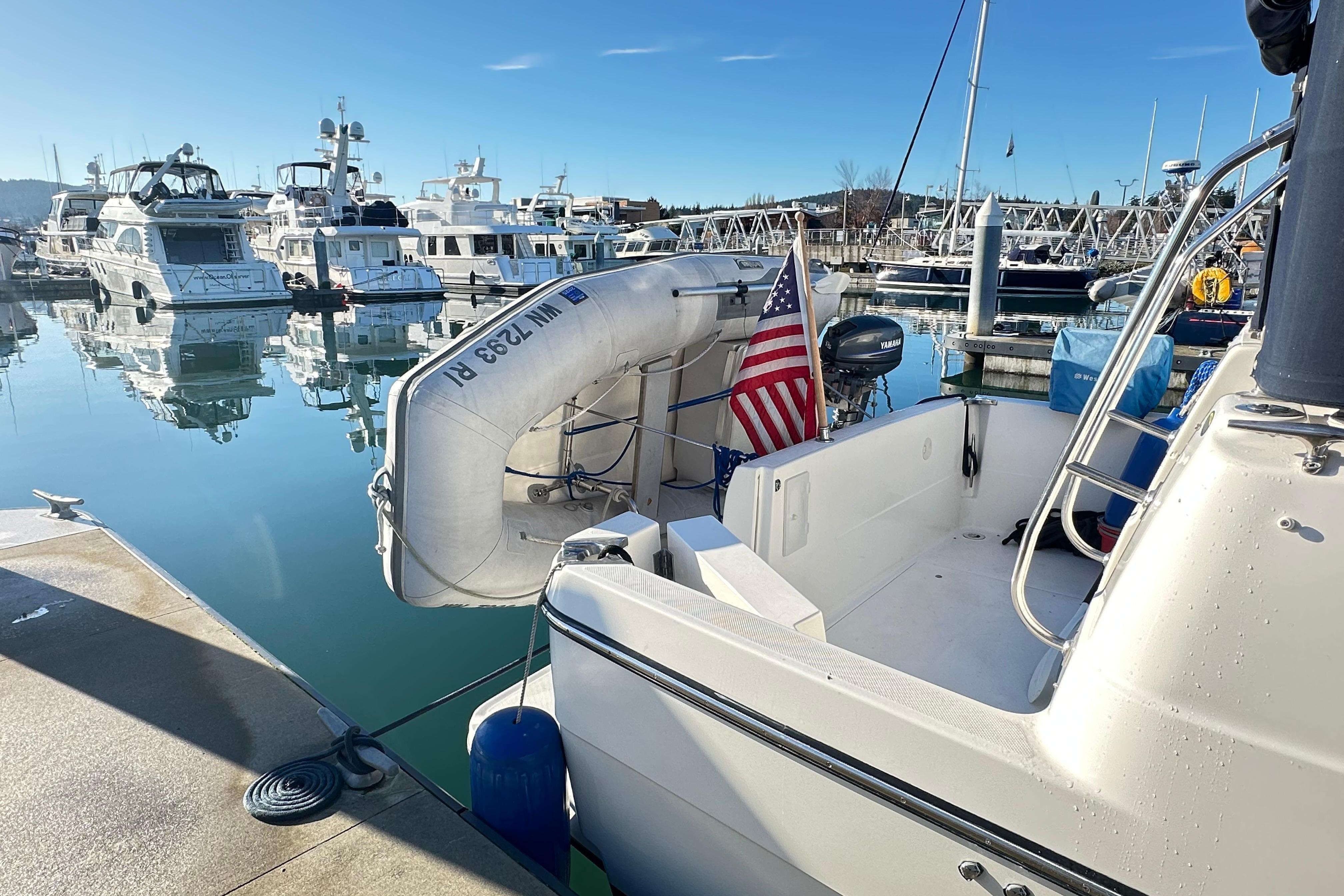 Bayliner 4087 Aft Cabin Motoryacht 2000 docked with inflatable boat and American flag.