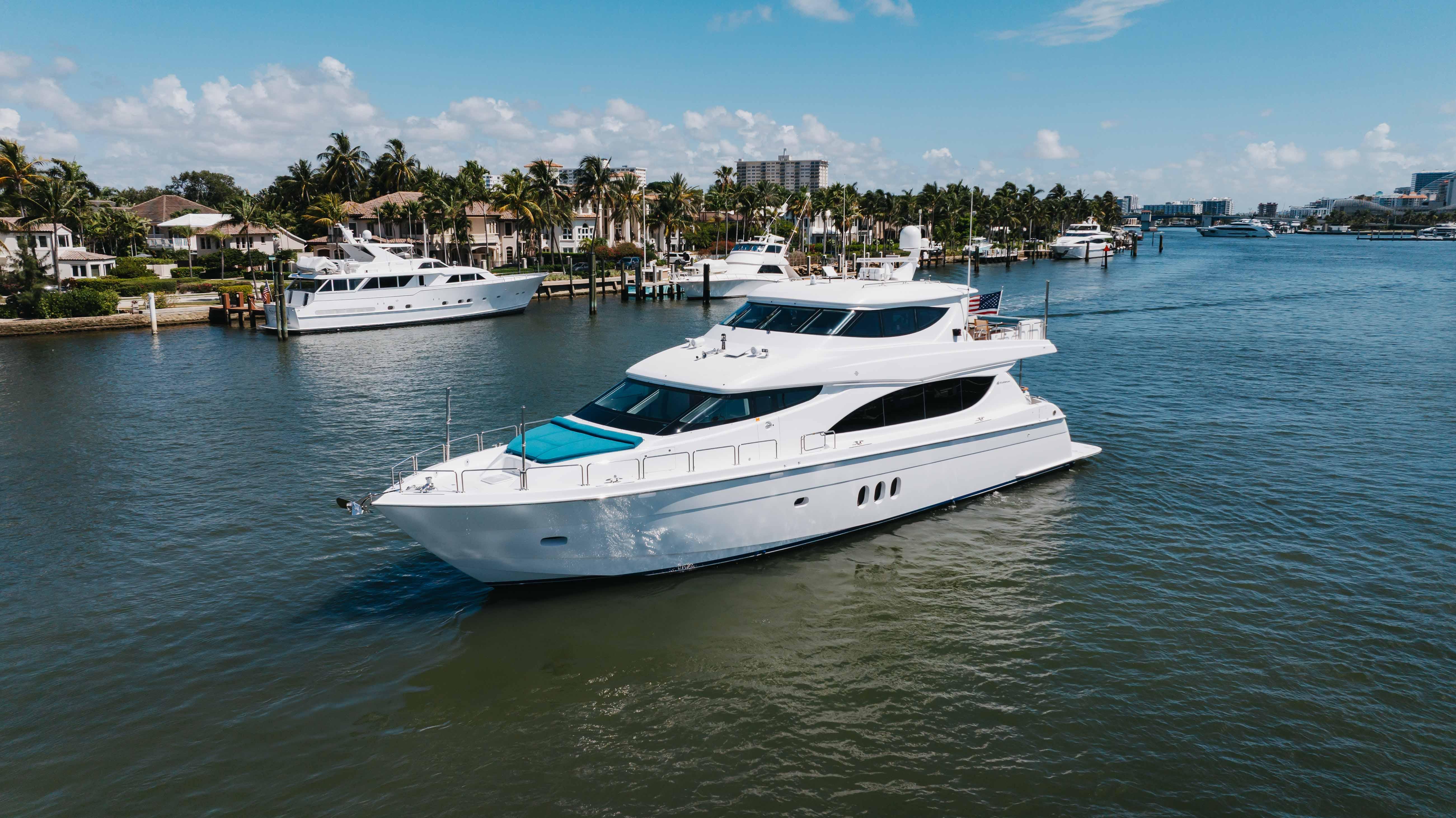 2014 Hatteras 80 Motor Yacht Sky Lounge cruising in a scenic waterfront setting.