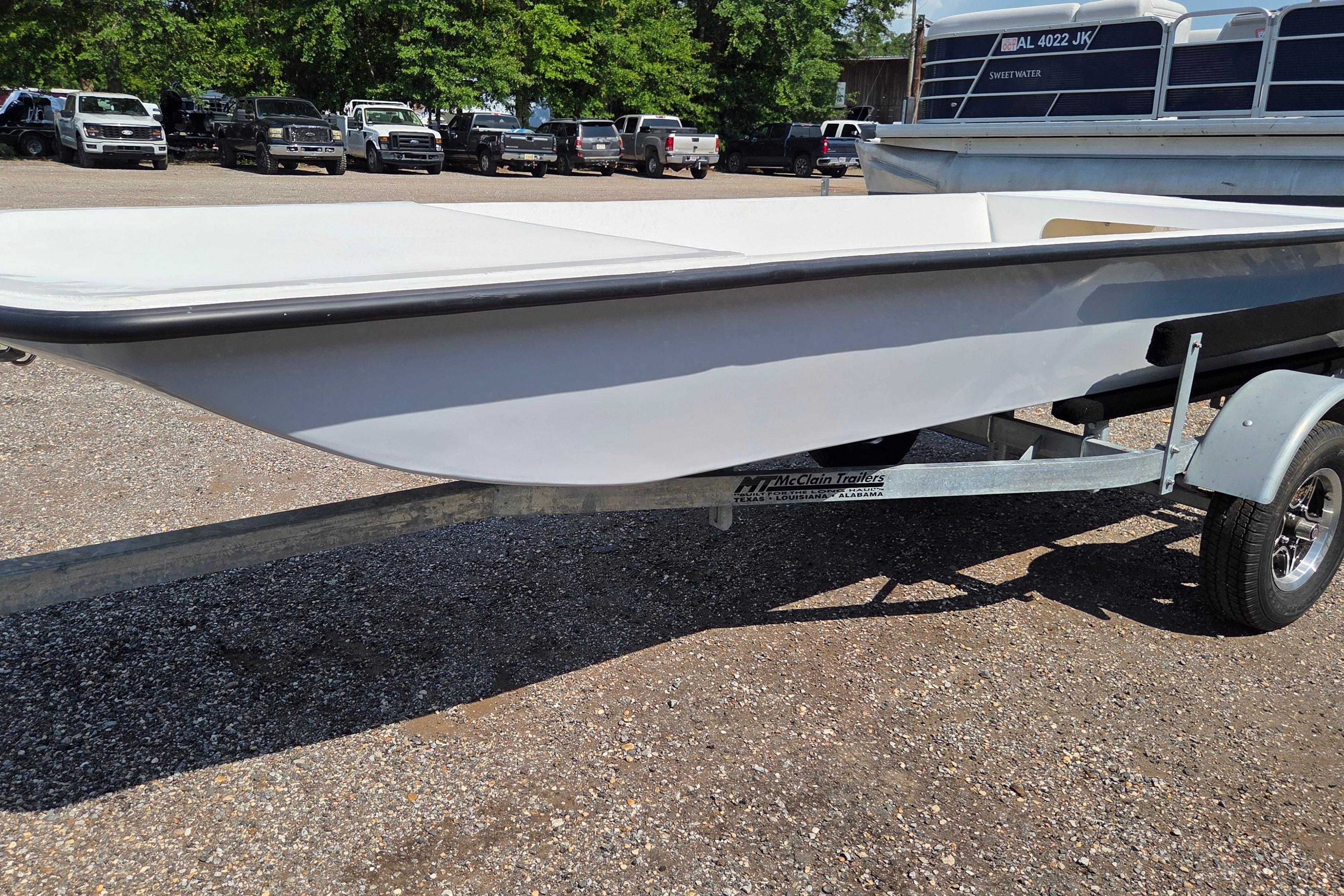 2027 Delta Boatworks 1550 on trailer in parking lot, surrounded by trucks.