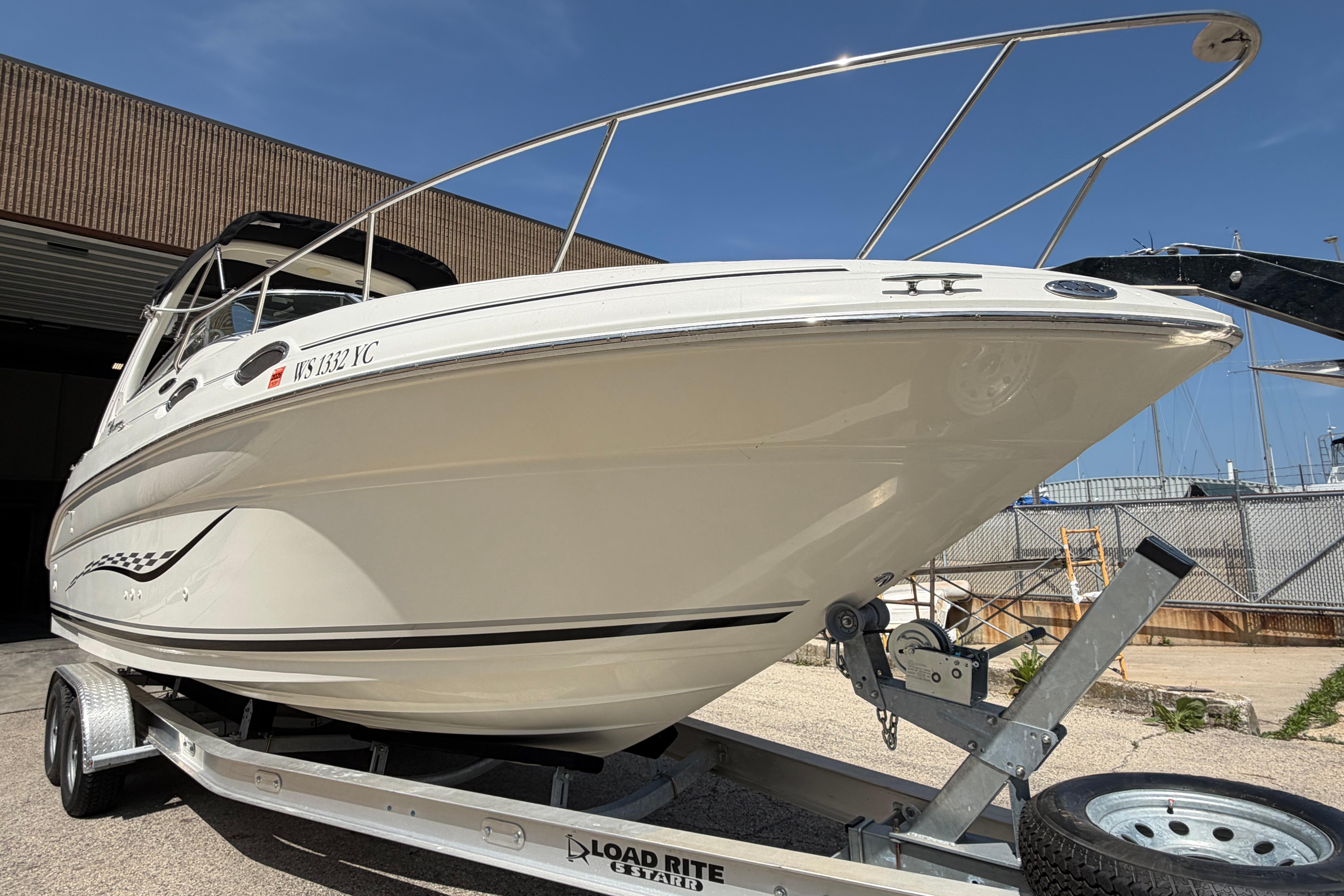 2004 Sea Ray Sundancer 260 boat on trailer, ready for transport under clear blue sky.