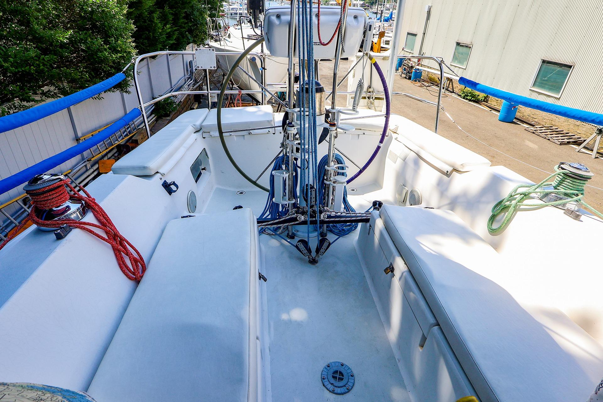 2001 J Boats J/32 sailboat cockpit with steering wheel and rigging, docked at marina.
