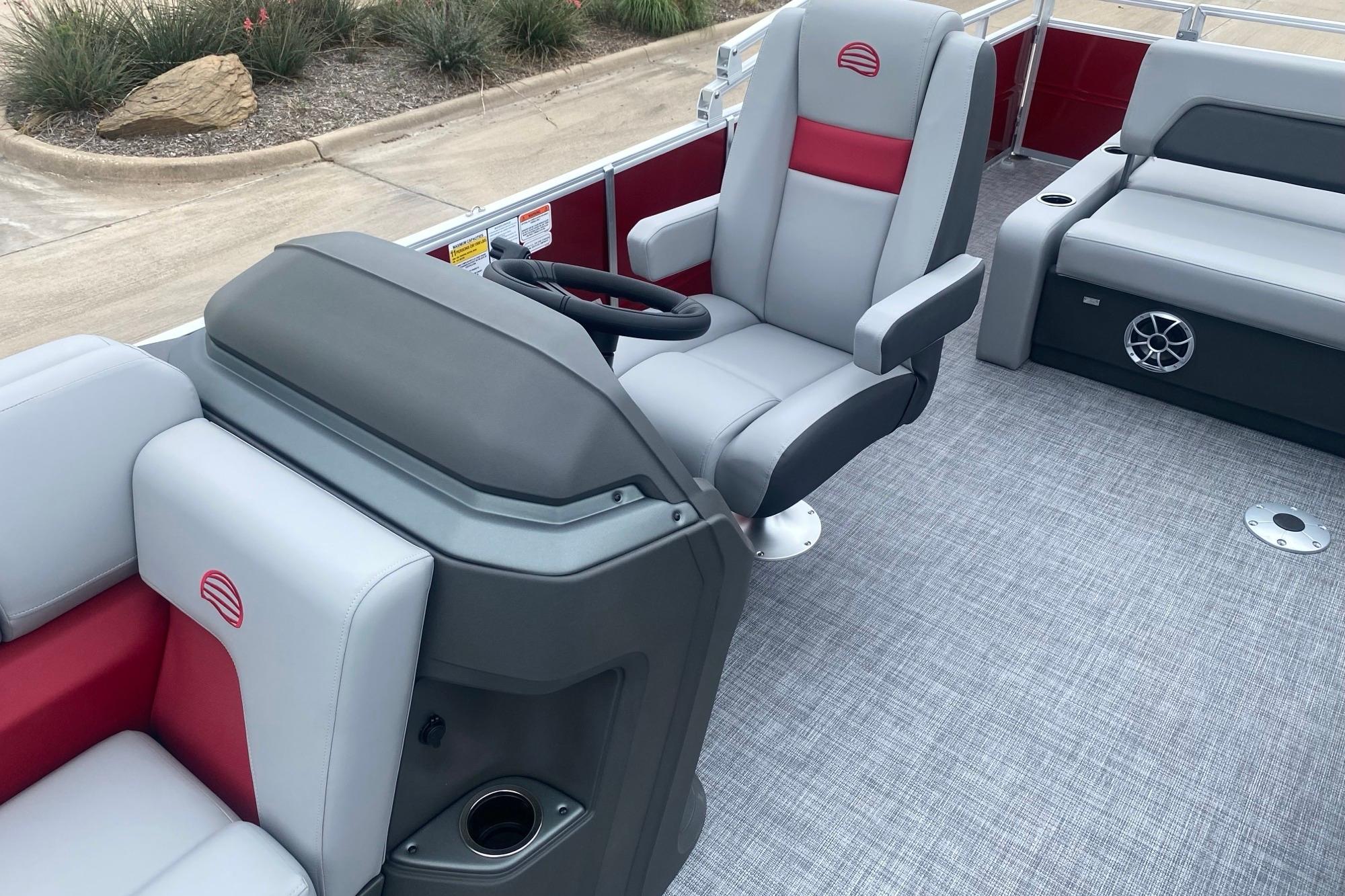 2026 Sun Tracker Party Barge 22 RF DLX interior with gray and red seating, steering console.