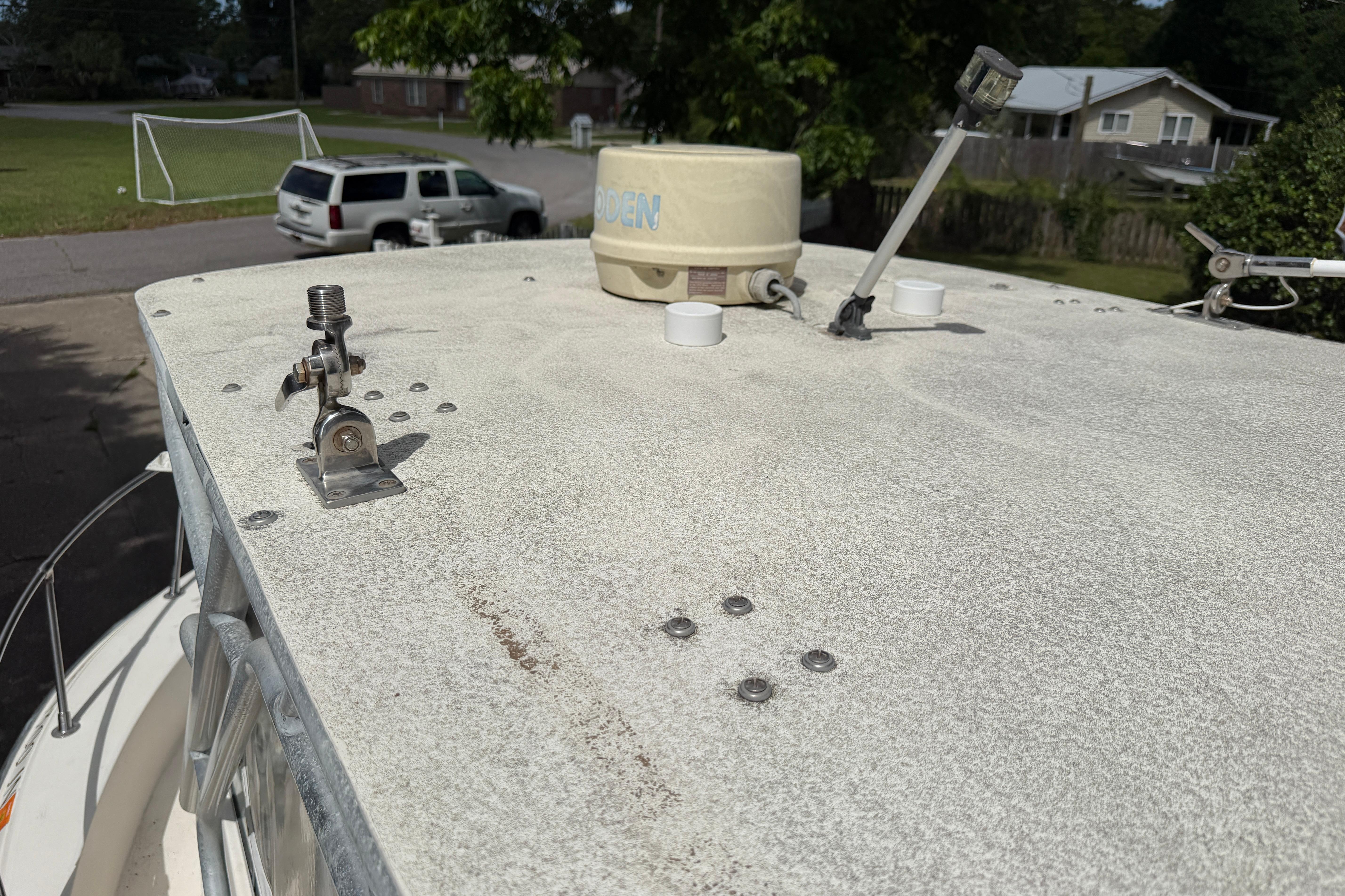 1987 Grady-White Seafarer 226 boat roof with antennas and equipment, parked in a residential area.