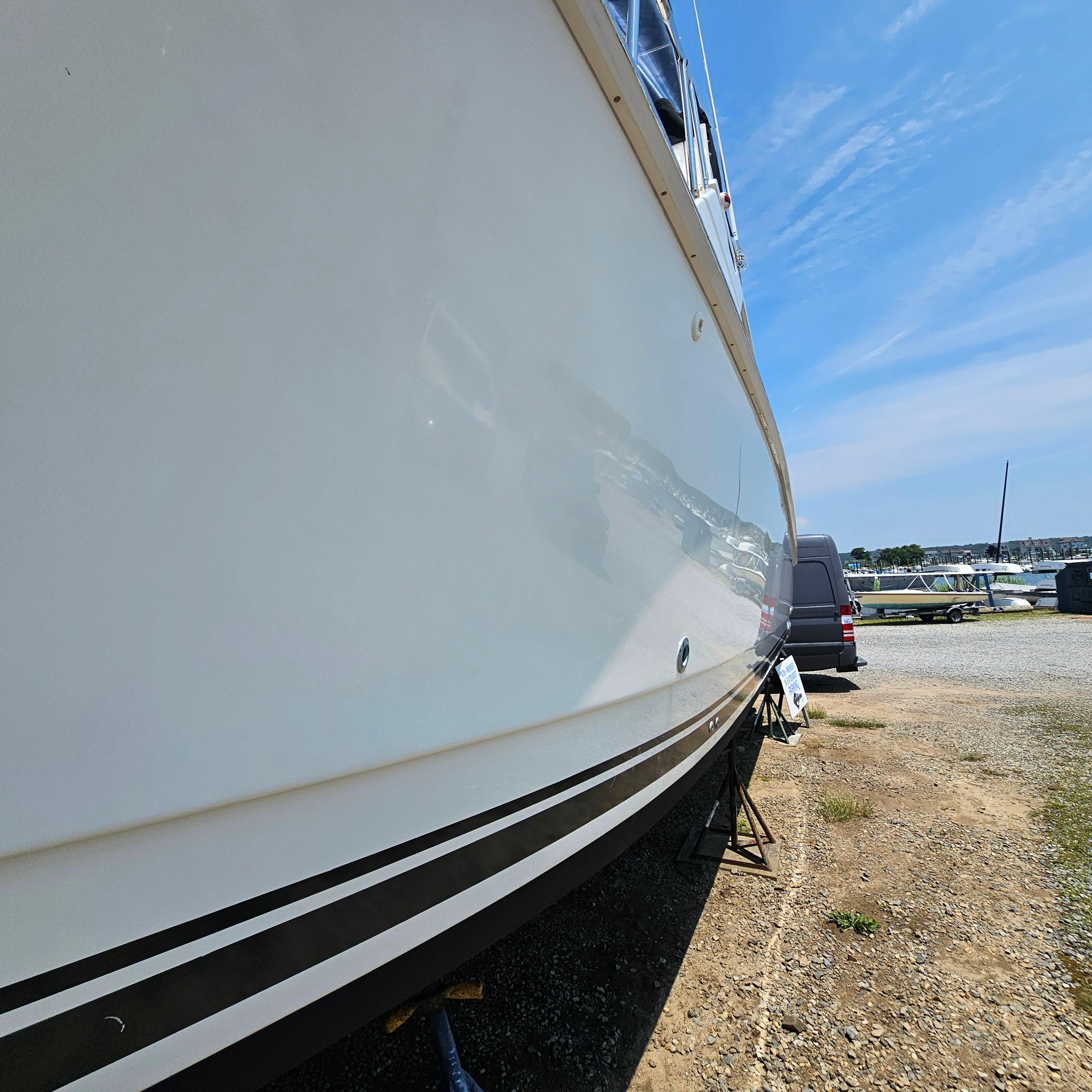 Side view of a 2000 Silverton 392 Motor Yacht on dry land under a clear sky.