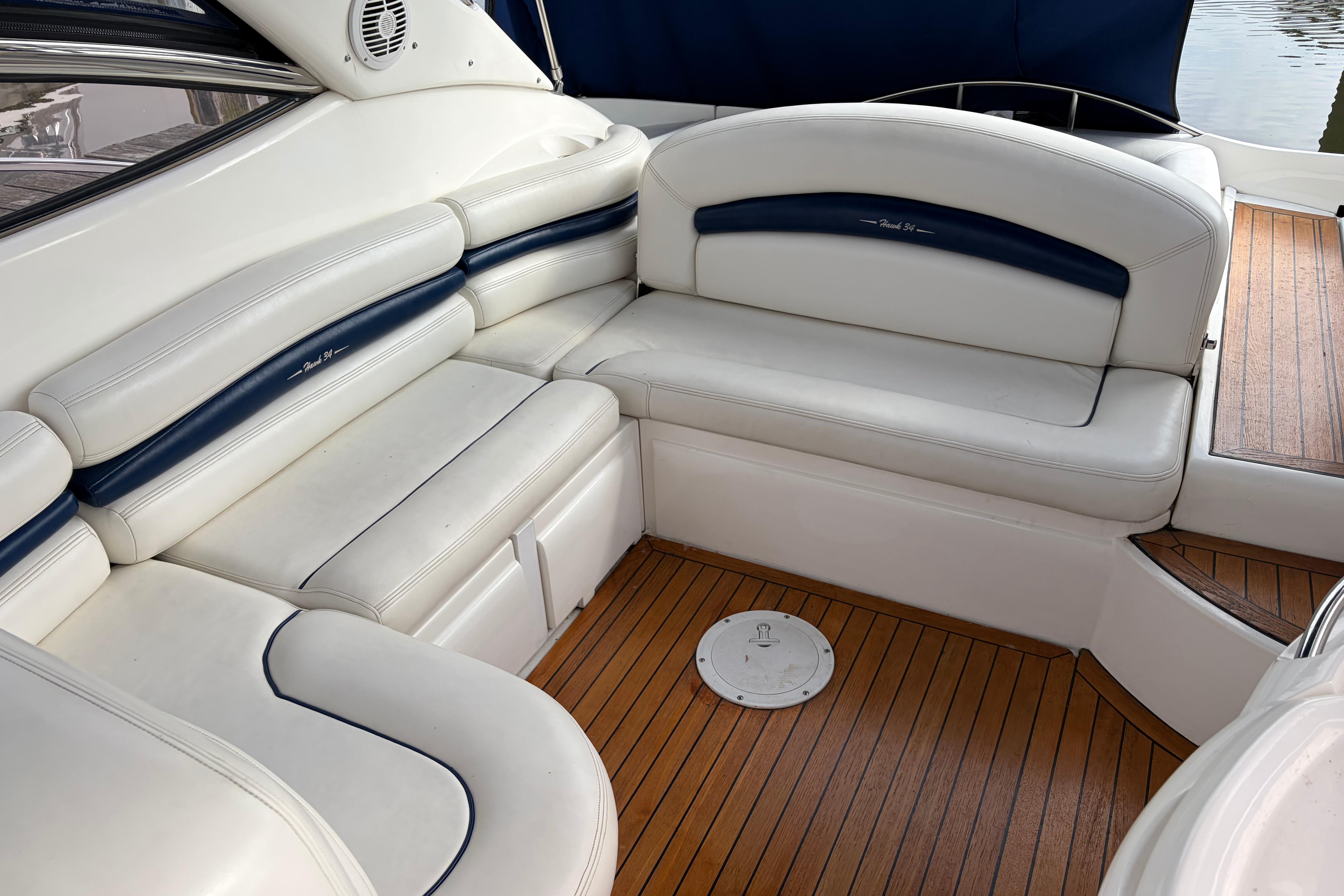 Luxurious seating area on a 2000 Sunseeker Superhawk 34 yacht with wooden flooring.