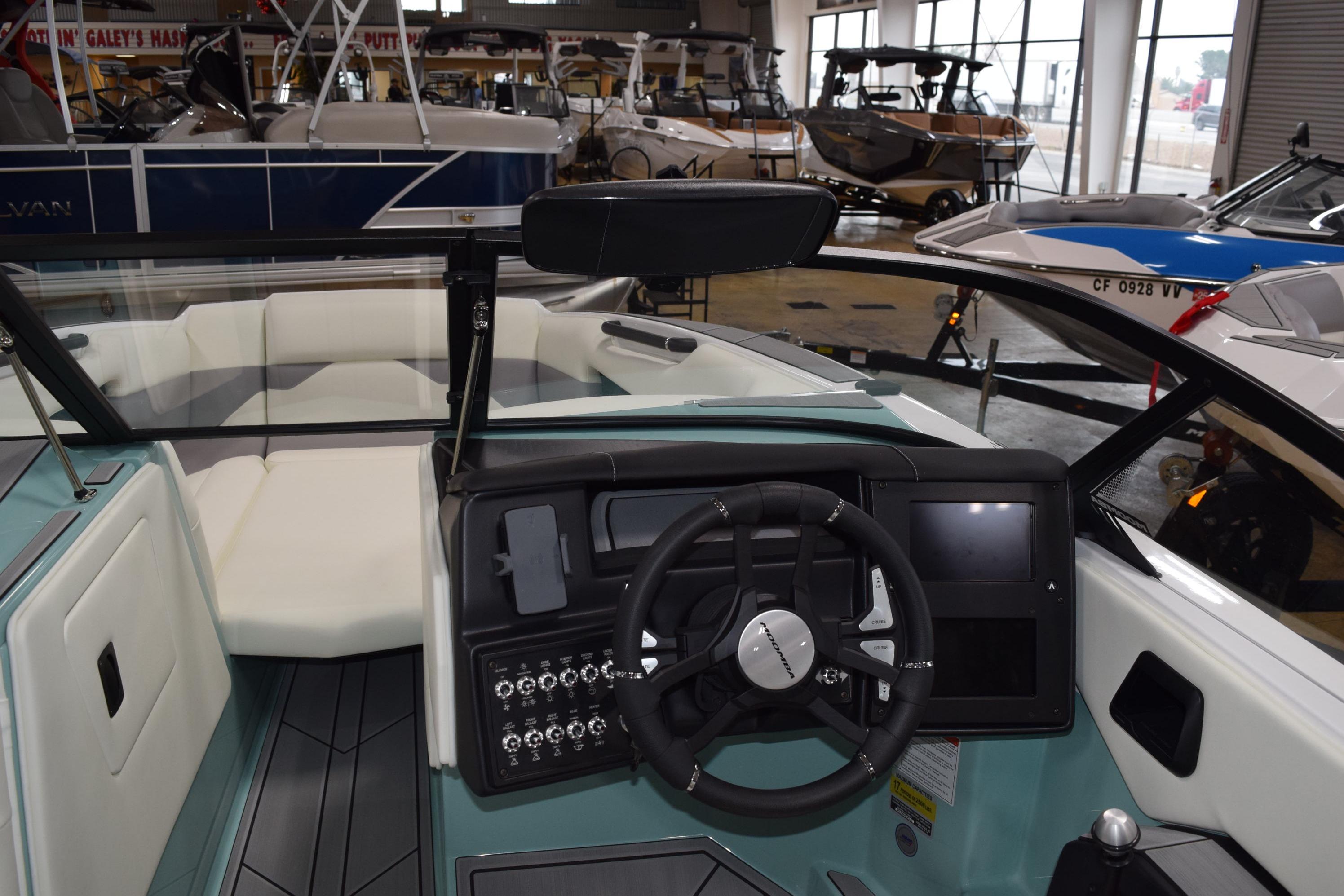 2025 Moomba Mojo boat interior with steering wheel and dashboard in showroom.