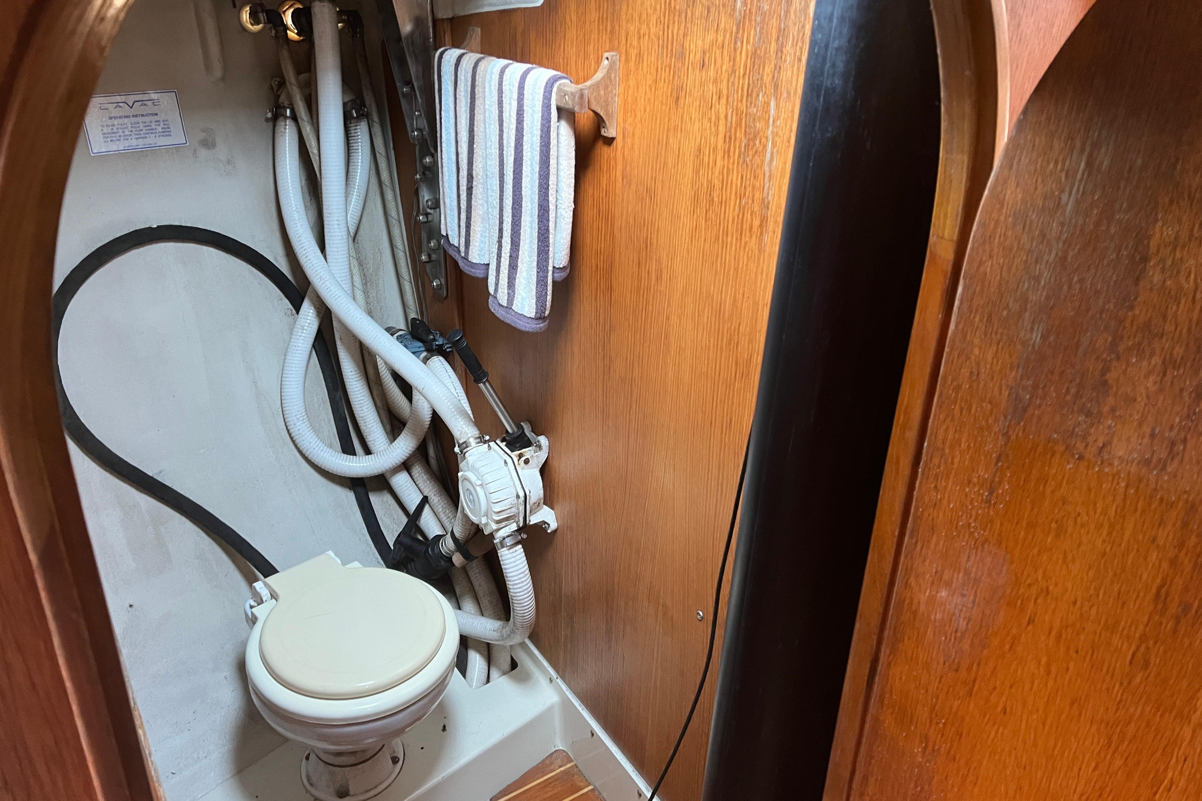 Compact marine toilet in 1986 Alsberg Brothers Express 37 sailboat bathroom.