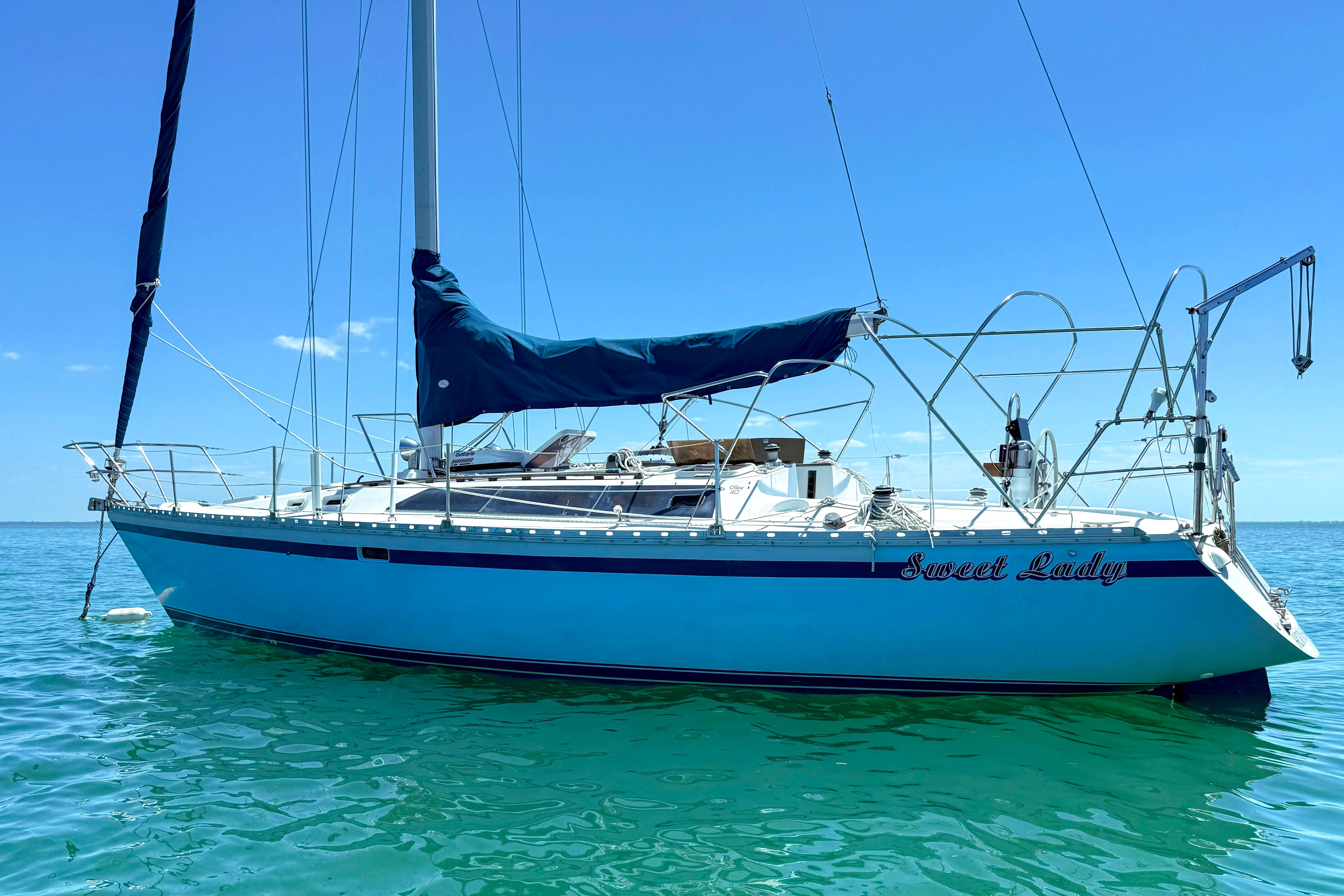 1988 Oday 40 sailboat named "Sweet Lady" on clear blue water.