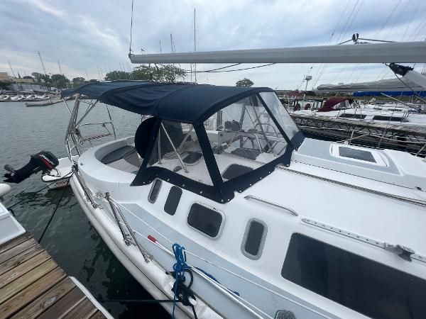 2000 Hunter 410 sailboat with blue canvas cover, docked at a marina.