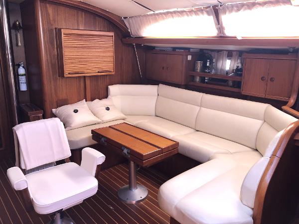 Luxurious interior of 2001 Jeanneau 45.2 yacht with white leather seating and wooden accents.