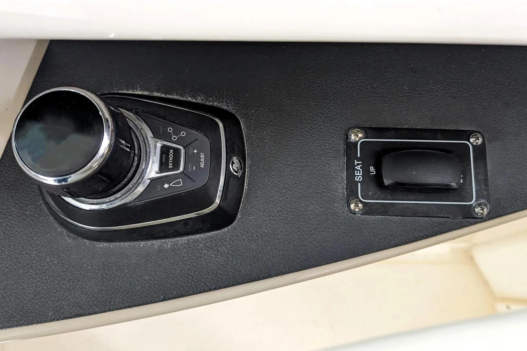 Control panel of a 2017 Boston Whaler 320 Vantage boat with joystick and seat adjustment.