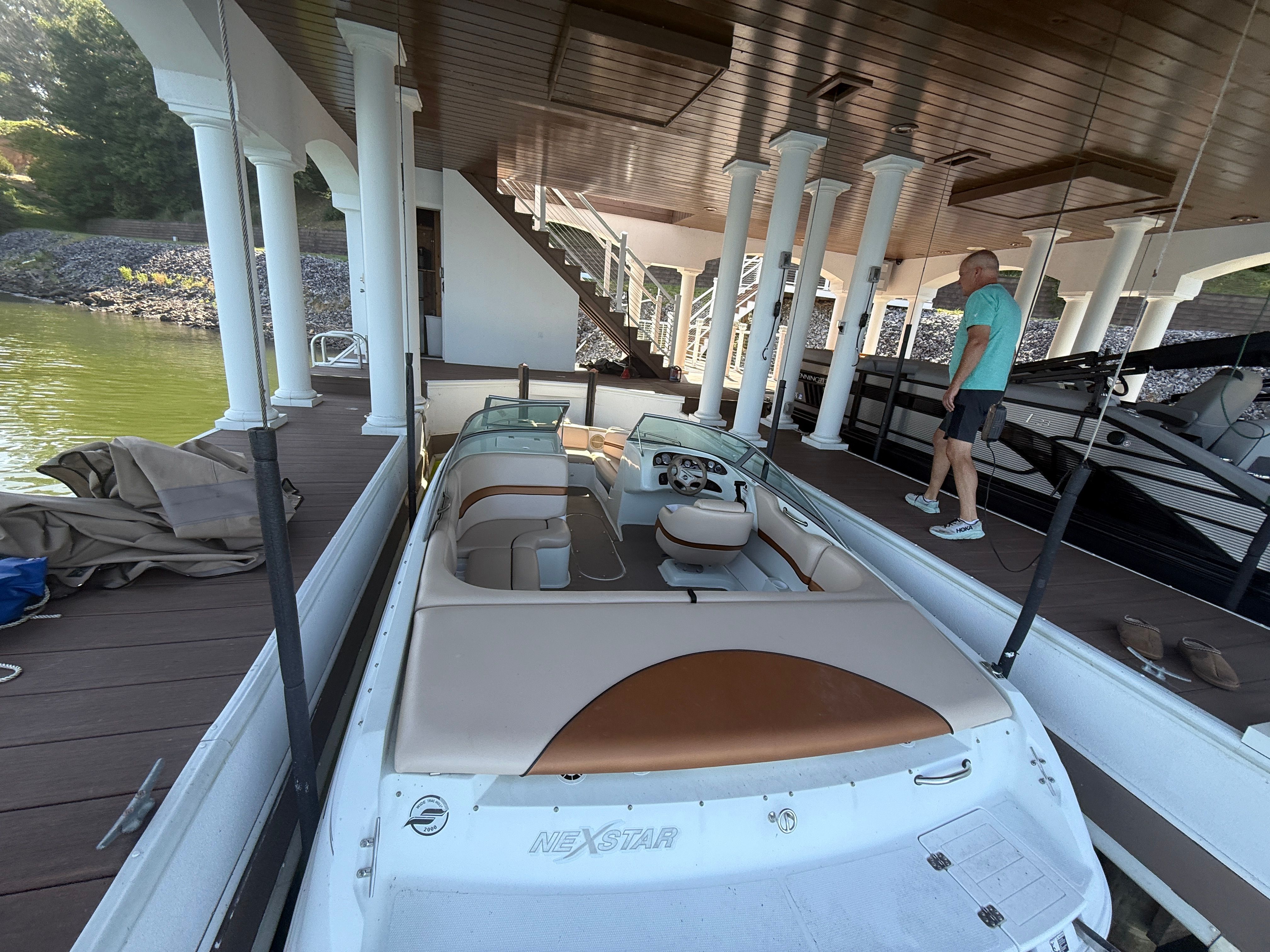 A 2000 Starcraft Next Star 19 boat docked under a covered pier.