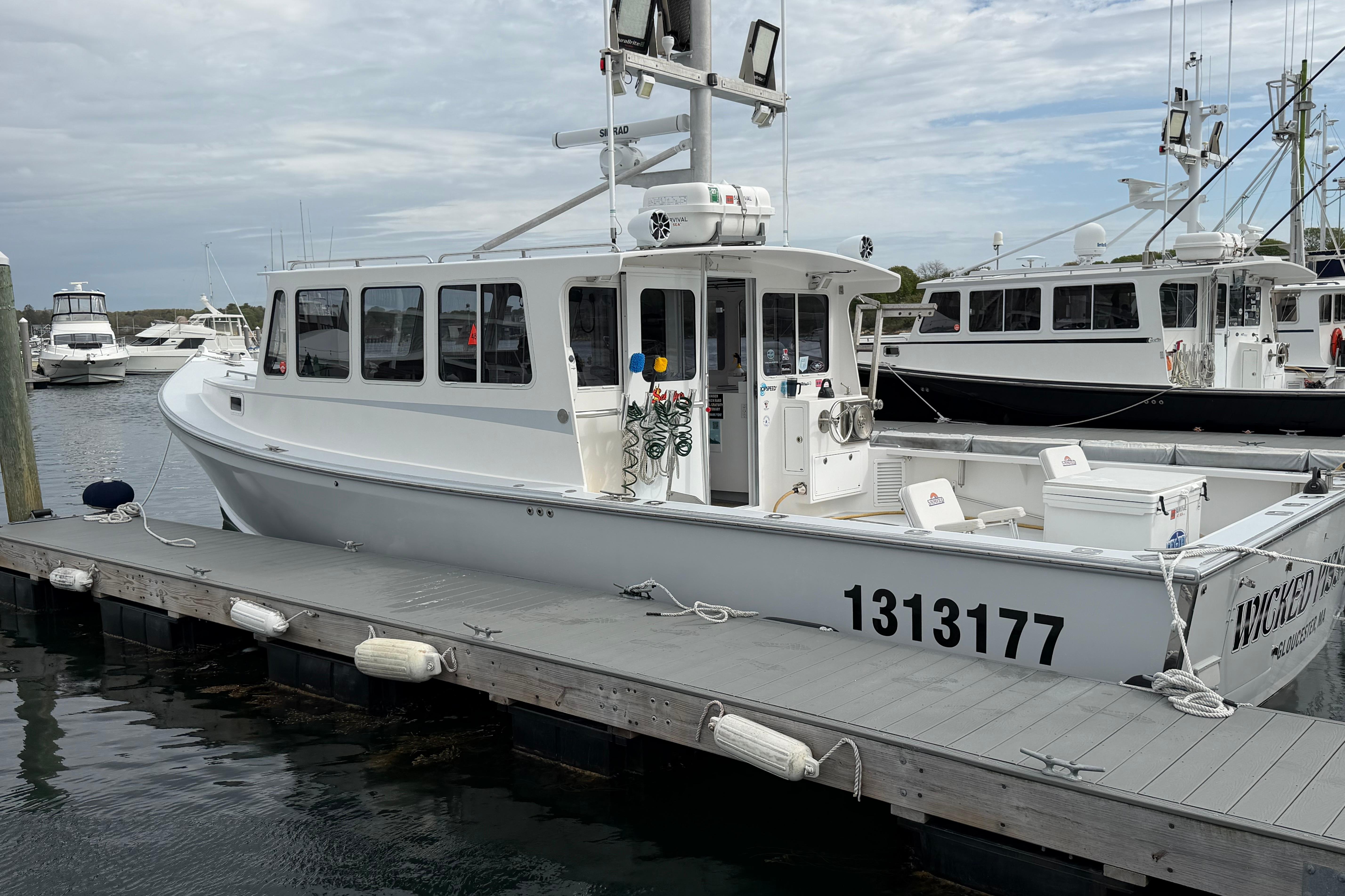 2018 H&H Marine Osmond Beal boat docked at marina, featuring sleek white design.