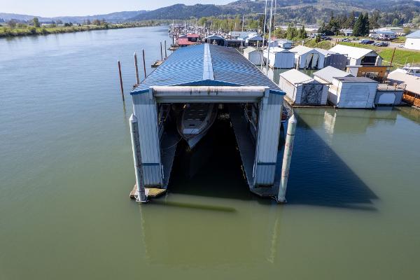 Aerial view of a 1985 Custom Larson Boathouse on a serene river.