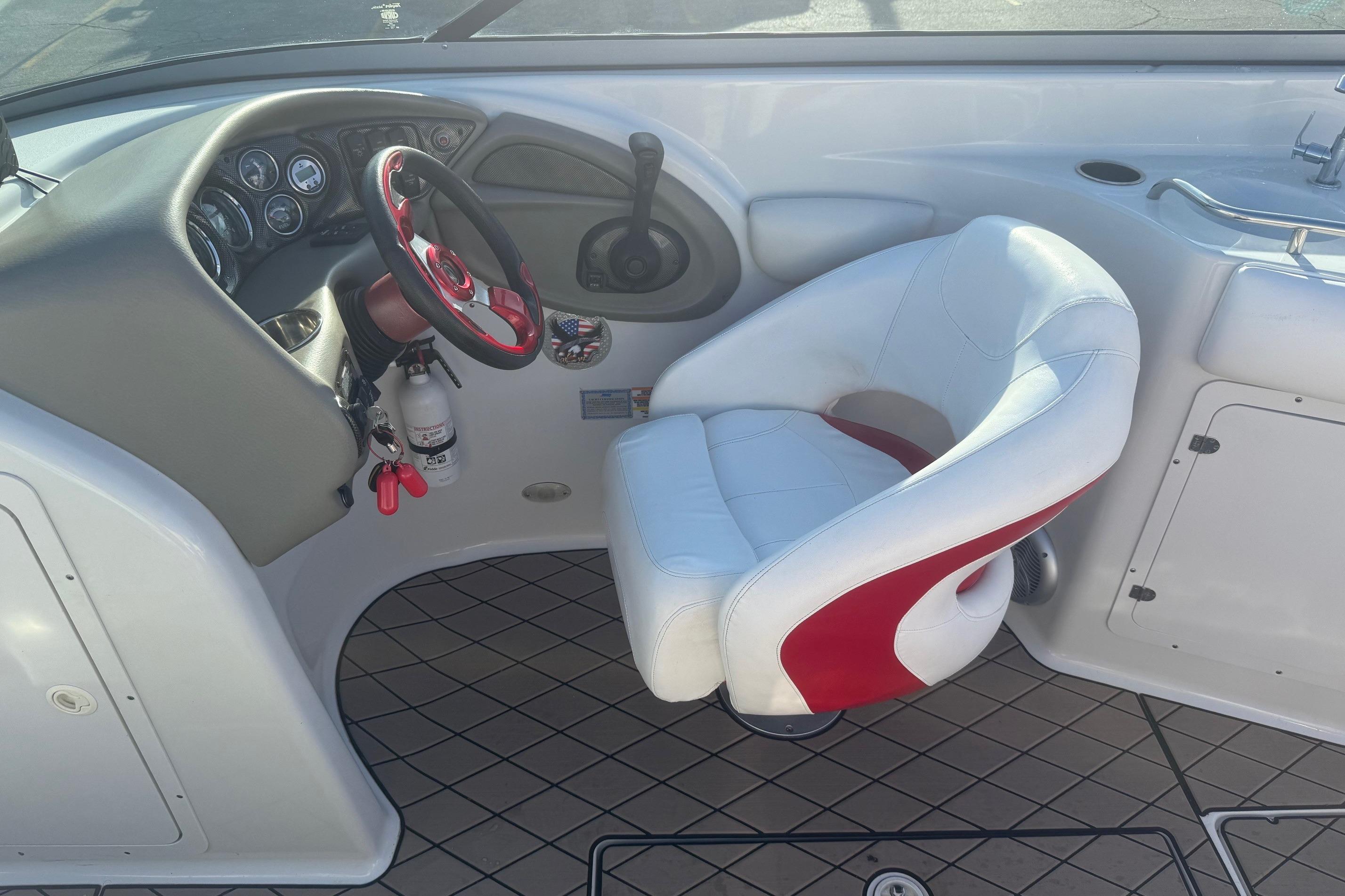Cockpit of 2005 Crownline 270 BR boat with steering wheel and captain's chair.