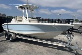 2024 Boston Whaler 220 Dauntless boat on trailer, parked outdoors.