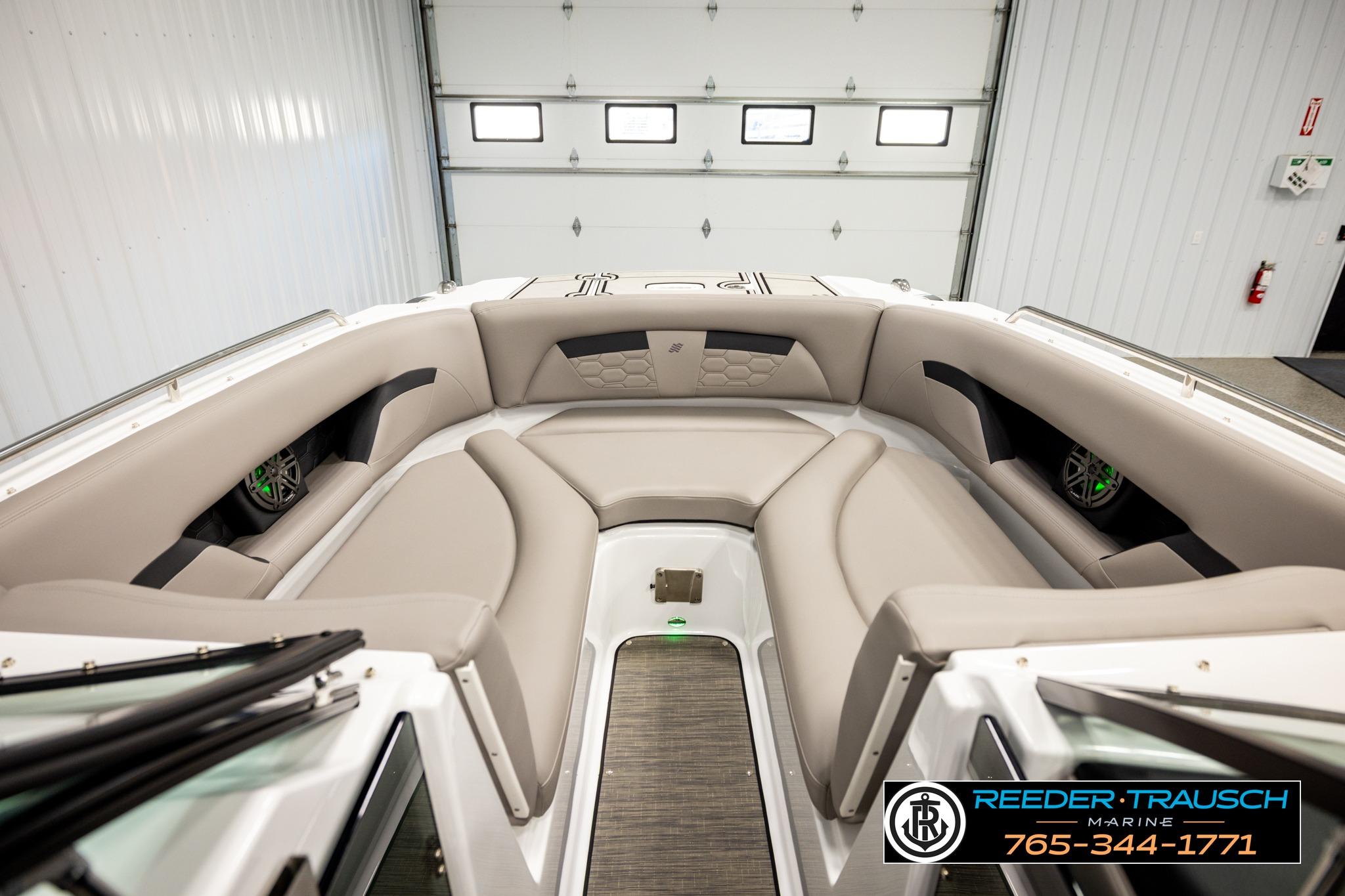 2024 FOURWINNS HD5 Surf boat interior with beige seating in a showroom.