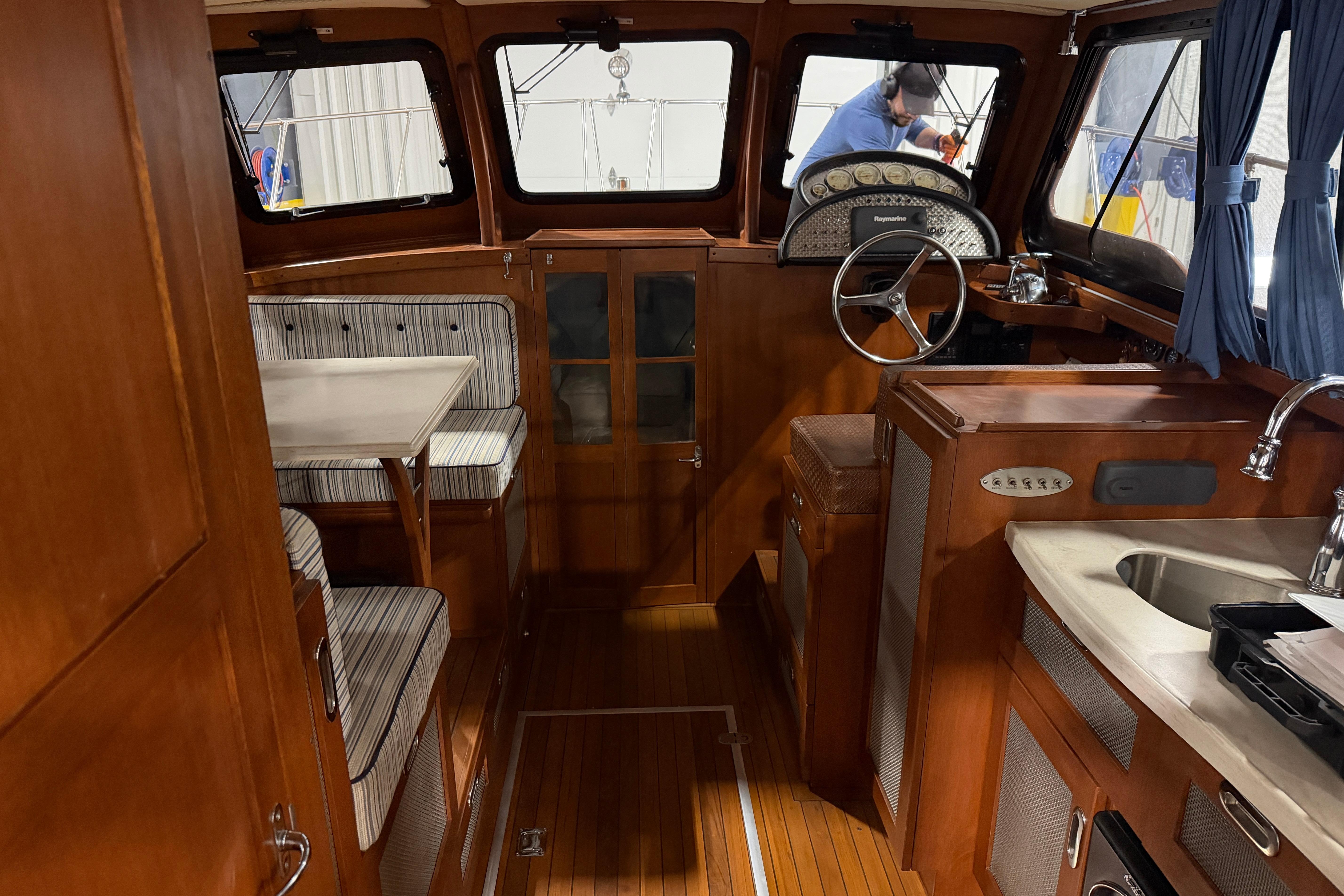 1986 Skiff Craft X-31 Sportsman Custom interior with wood finish, dining area, and steering wheel.