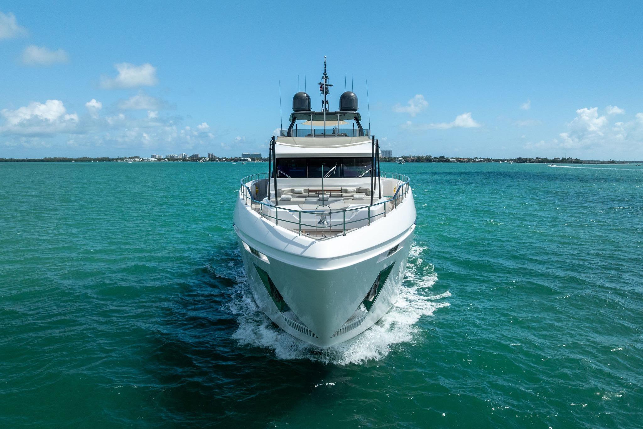 Luxurious 2023 Custom Line Navetta 33 yacht cruising in turquoise waters under clear skies.