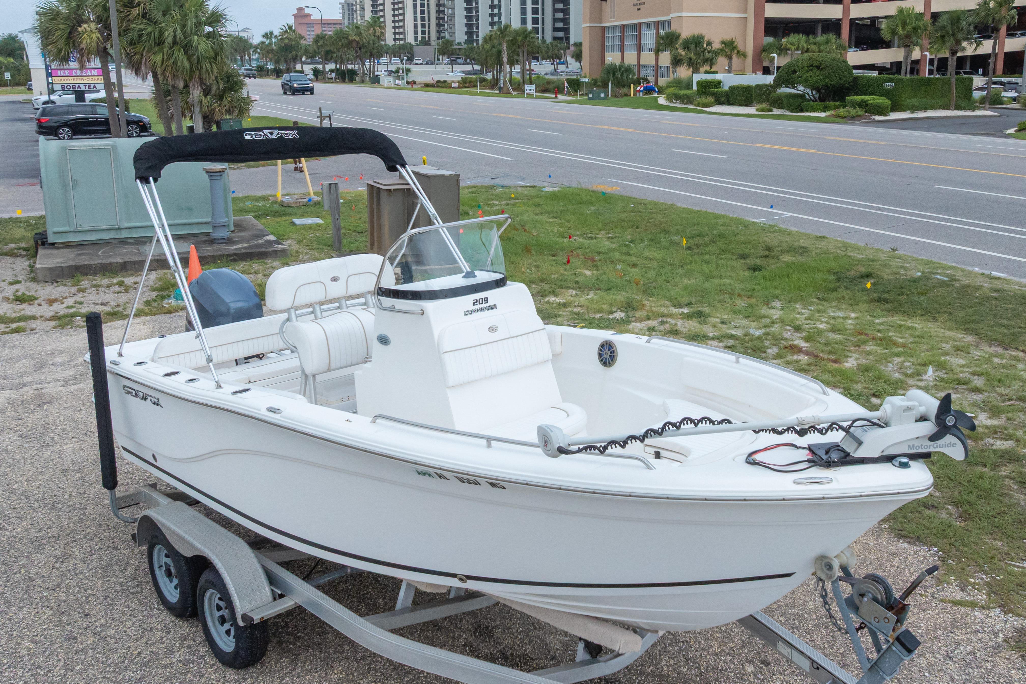 2014 Sea Fox 209 Commander boat on trailer, parked near a road.