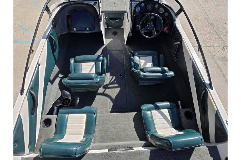 1997 Javelin 389 FS boat interior with teal and white seating, steering wheel, and dashboard.