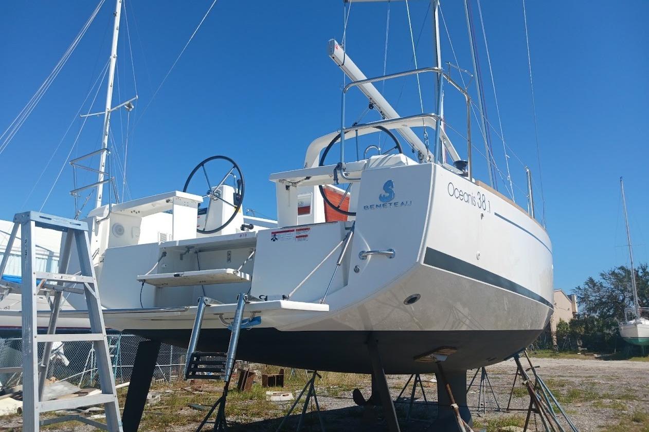 2023 Beneteau Oceanis 38.1 sailboat on land, rear view with clear blue sky.