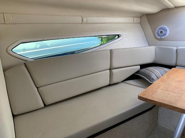 Interior of a 2017 Regal 26 Express with beige upholstery and a wooden table.