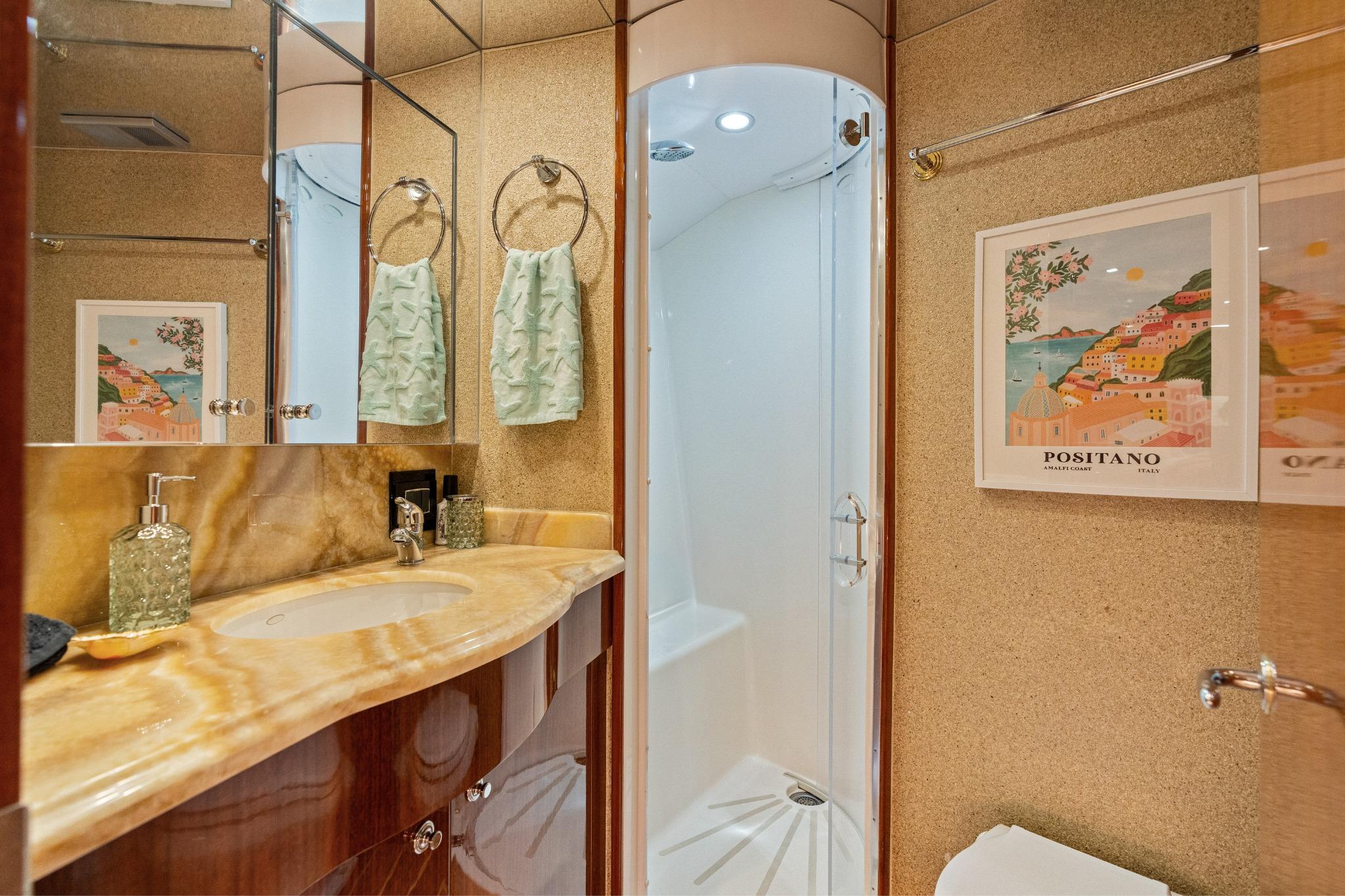 Luxurious bathroom in 2008 Hatteras 64 Motor Yacht with elegant fixtures and Positano artwork.