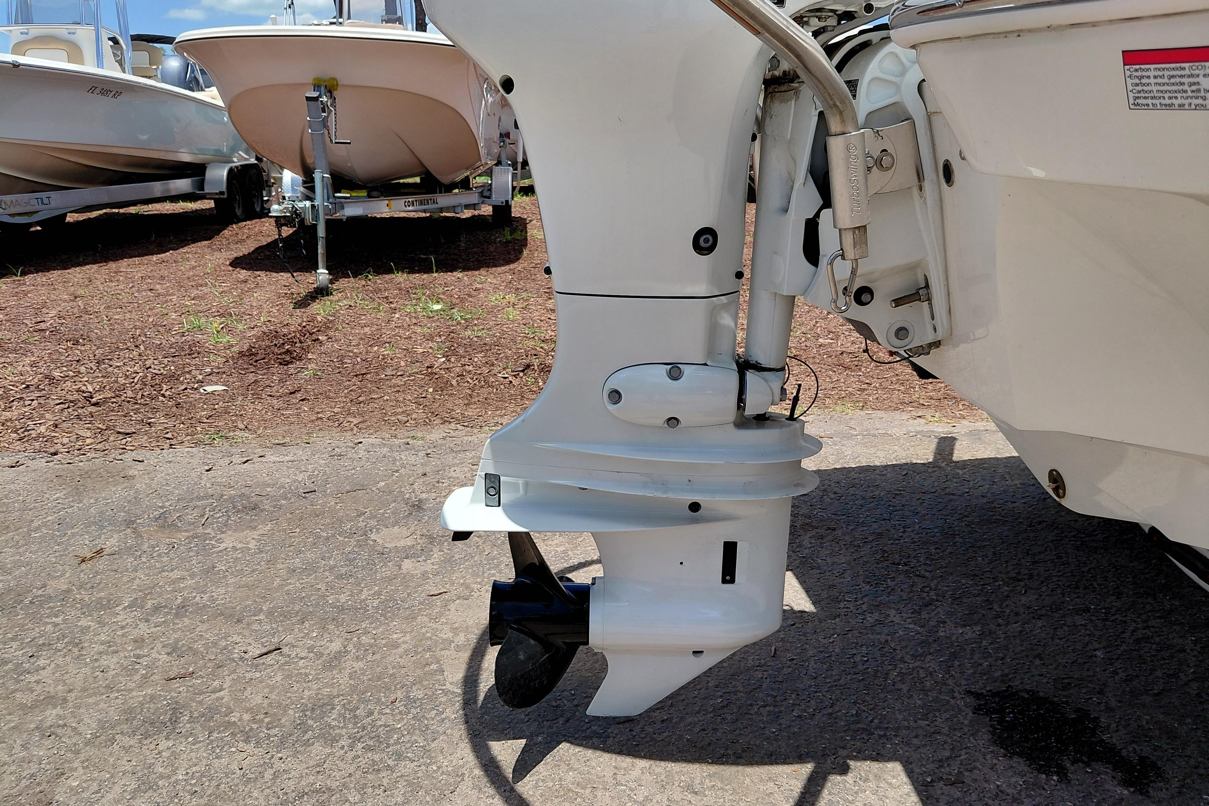 Outboard motor of a 2023 Stingray 206 CC boat, parked on a sunny day.