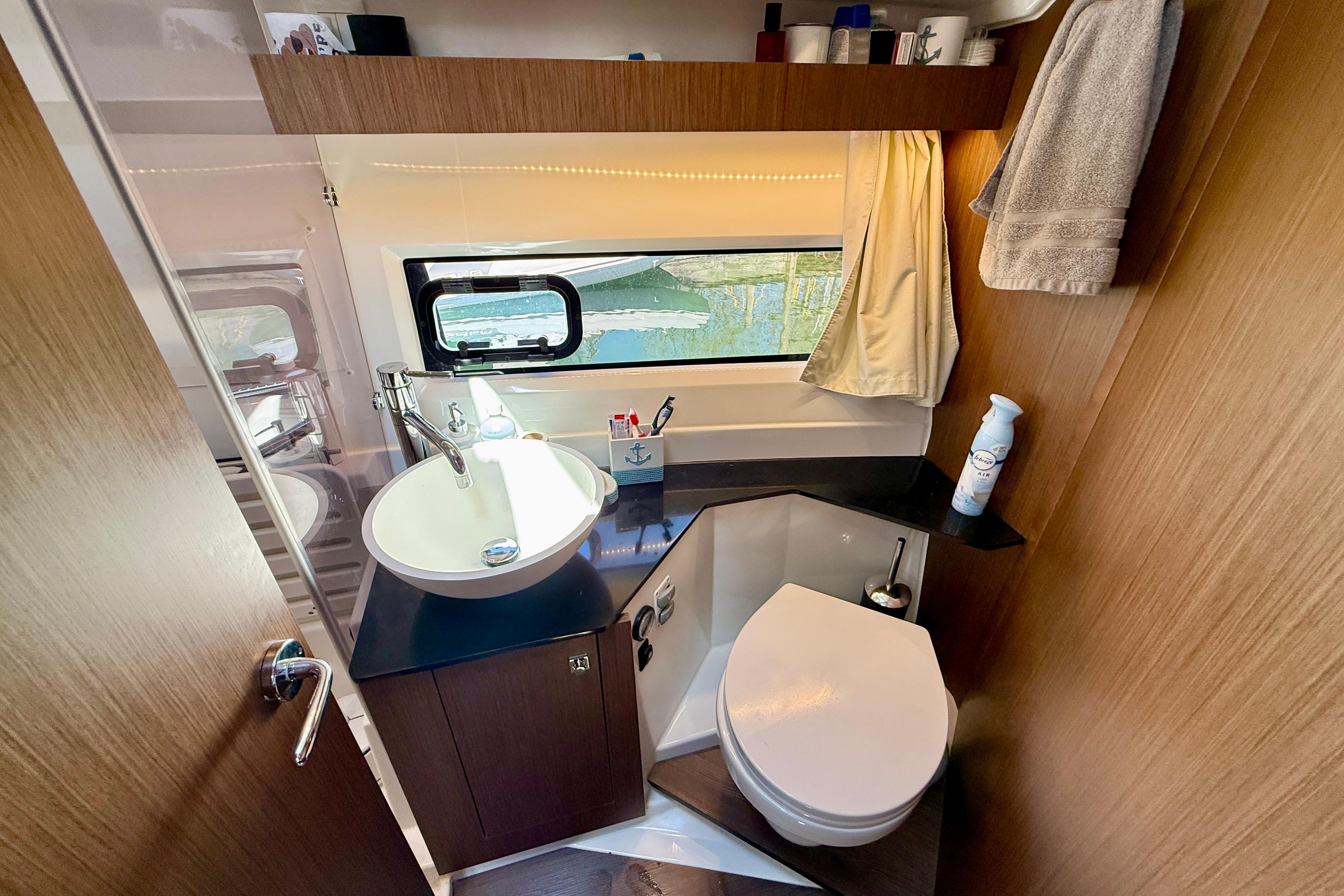 2022 Jeanneau NC 1095 Fly bathroom with modern sink, toilet, and window view.