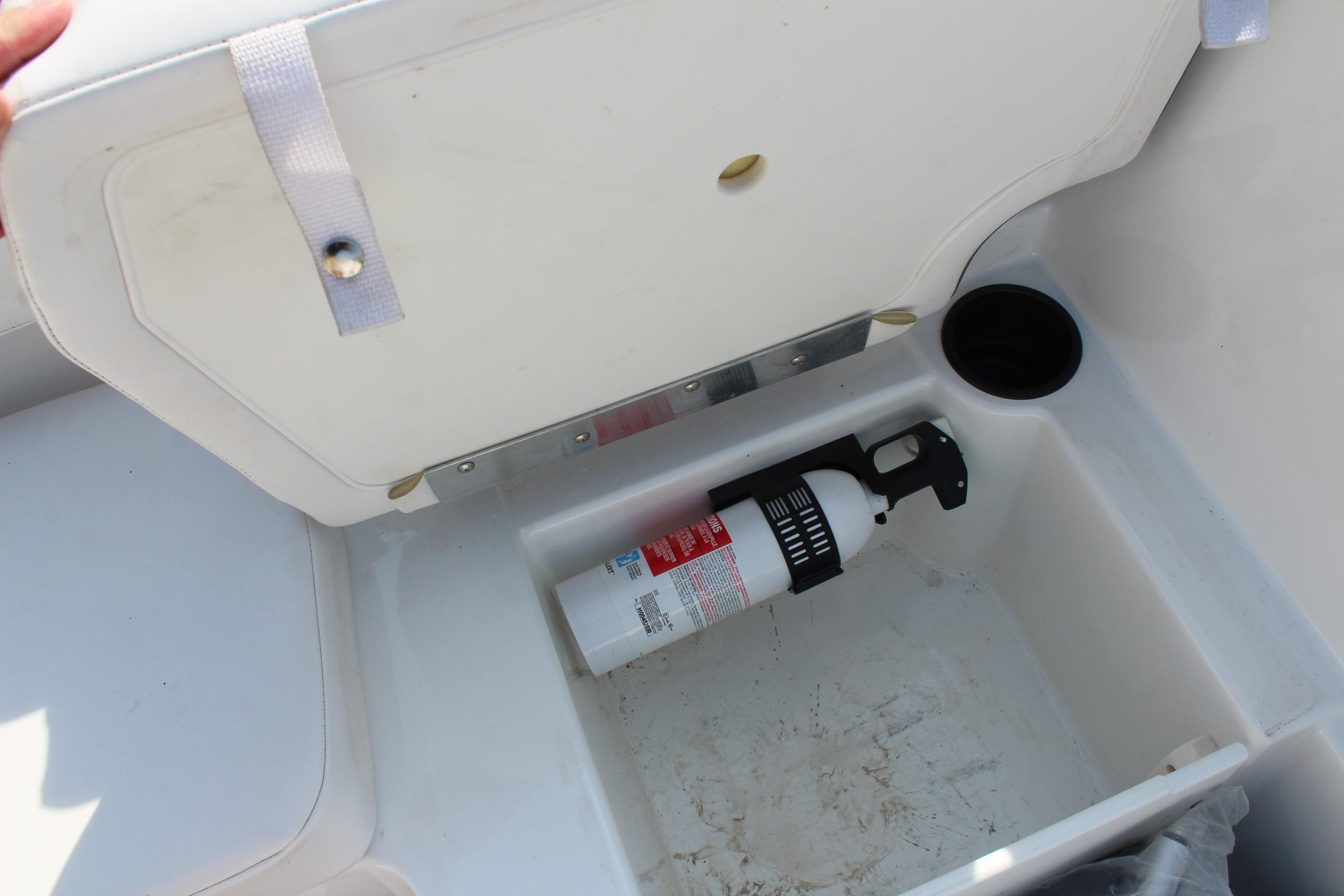 2023 Tahoe T16 storage compartment with fire extinguisher and cup holder.