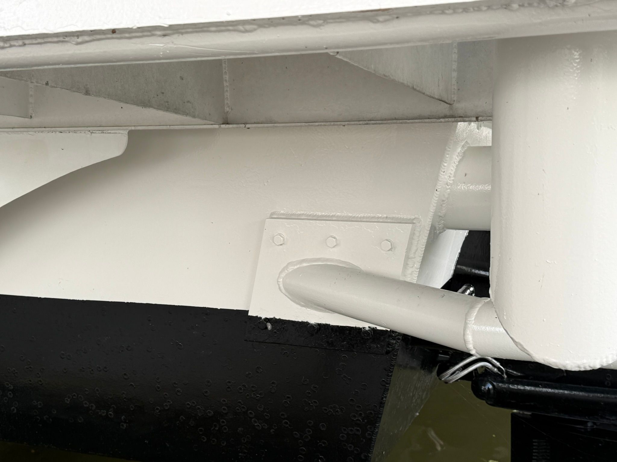Close-up of a white and black boat hull with structural details.